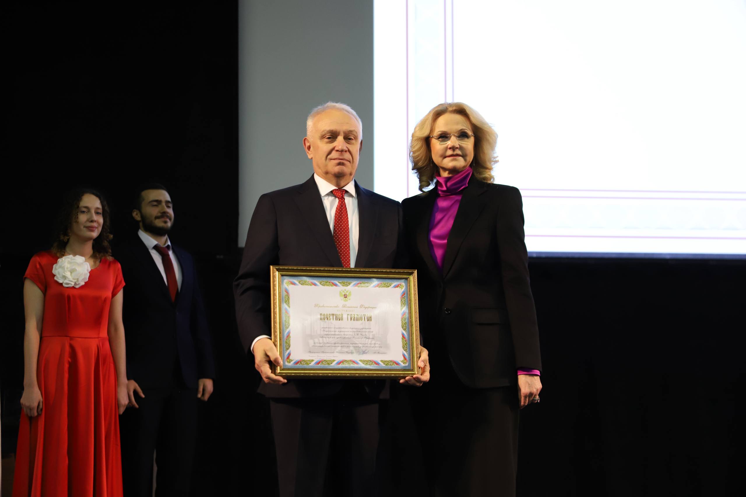 Татьяна Голикова поздравила с 80 летием Национальный медицинский исследовательский центр кардиологии имени академика Чазова НМИЦ кардиологии имени академика Чазова прошел очень знаковый путь который превратил небольшое подразделение Академии медицинских наук СССР в мощный высокотехнологичный медицинский центр На протяжении многих лет центр выступает головной организацией по направлению кардиология в нашей стране является разработчиком передовых программ которые вместе с лучшими медицинскими практиками внедряет в регионах В период реализации в 2019 2024 годах национального проекта Здравоохранение и сейчас в рамках нового национального проекта Продолжительная и активная жизнь центр является флагманским по отношению к самому серьезному направлению борьба с сердечно сосудистыми заболеваниями сказала Татьяна Голикова Вице премьер подчеркнула что с 2019 по 2024 год в регионах создано 653 сосудистых центра При непосредственном участии НМИЦ кардиологии открыто более 150 региональных сосудистых центров Приобретено для учреждений регионов более 28 тыс единиц медицинского оборудования и 670 единиц тяжелого оборудования Сотрудниками Чазовского центра созданы десятки оригинальных методов диагностики и лечения сердечно сосудистых заболеваний разработаны и внедрены в практику целый ряд уникальных эффективных лекарственных препаратов не имеющих мировых аналогов Татьяна Голикова добавила что внедрение новых передовых технологий делает возможным снижение смертности и улучшение качества жизни кардиологических больных Так за последние 6 лет число рентгенэндоваскулярных вмешательств в лечебных целях увеличилось почти на 55 а больничная летальность от инфаркта миокарда снизилась более чем на 25 2 Татьяна Голикова вручила государственную награду Российской Федерации медаль ордена За заслуги перед Отечеством II степени руководителю отдела сердечно сосудистой хирургии ФГБУ НМИЦ кардиологии имени академика Е И Чазова Минздрава России Ширяеву Андрею Андреевичу Почетные грамоты Правительства Российской Федерации вице премьер вручила коллективу ФГБУ НМИЦ кардиологии имени академика Е И Чазова Минздрава России и генеральному директору ФГБУ НМИЦ кардиологии имени академика Е И Чазова Минздрава России Бойцову Сергею Анатольевичу Подписаться на Правительство России в MAX