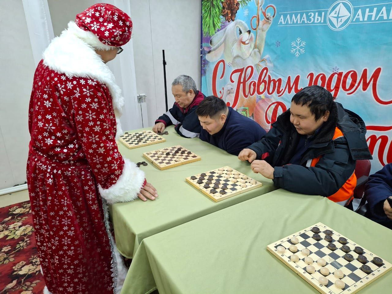 Дед Мороз провел сеанс одновременной игры в шашки на одном из приисков АО "Алмазы Анабара" группы АЛРОСА  На днях Дед Мороз провел сеанс одновременной игры в шашки на прииске "Молодо" АО "Алмазы Анабара" группы АЛРОСА. Роль Деда Мороза исполнил лесоруб Гаврил Попов, неоднократный чемпион прииска по шашкам.  Счёт: одна ничья с Петром Литвинцевым, слесарем РММ, и победа на четырех параллельных досках.  Денис Сухомясов, инженер связи, упустил шанс сыграть в ничью с Дедом Морозом, так как слишком увлекся и понадеялся на выигрыш. А Петр Литвинцев своего шанса не упустил, многолетний опыт помог шашисту прииска. Играл по принципу - "лучше синица в руке, чем журавль на небе".  Вот такие сказки от предновогоднего прииска "Молодо".  Мичил ГУРЬЕВ, прииск «МОЛОДО»