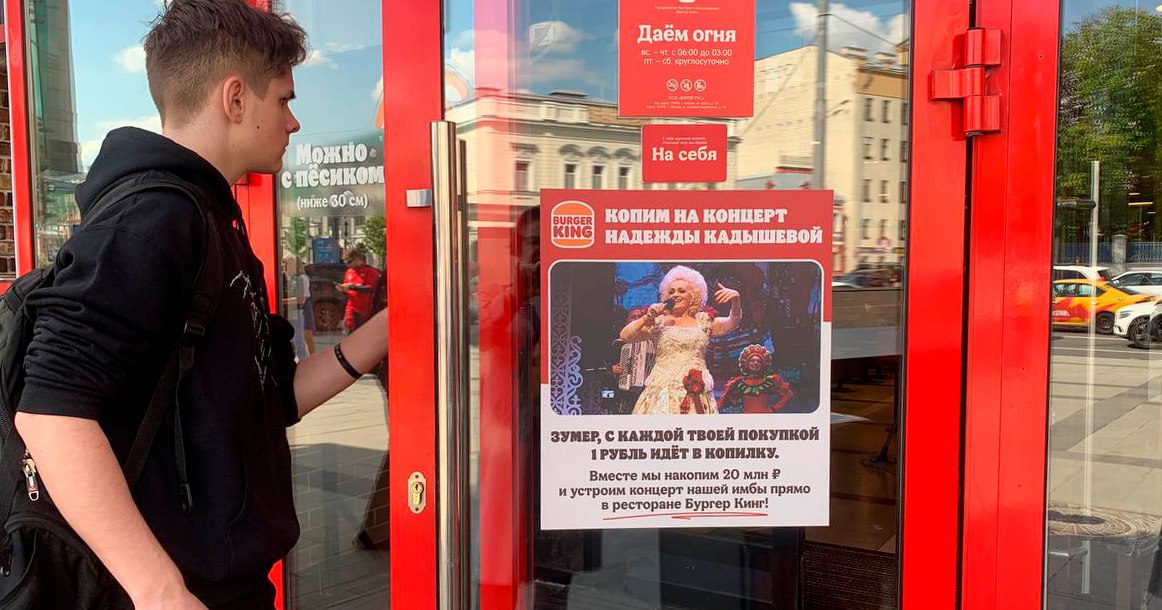 «Бургер Кинг» начал сбор средств на концерт Надежды Кадышевой в закусочной на «Баррикадной» После завирусившихся тиктоков Надежда Кадышева неожиданно стала самой высокооплачиваемой артисткой в России. Пока все изучают «феномен Кадышевой», «Бургер Кинг» решил пригласить певицу выступить прямо в одной из своих закусочных. Сегодня по телеграм-каналам разлетелось объявление, наклеенное на дверь одного из «Бургер Кингов», где сказано, что для концерта нужно собрать 20 млн рублей. Метят в основную аудиторию Кадышевой — зумеров. «С каждой твоей покупкой 1 рубль идет в копилку. Вместе мы накопим 20 млн рублей и устроим концерт нашей имбы прямо в ресторане!», — сообщает объявление. Как выяснил «Москвич Mag», наклейка появилась на двери ресторана недалеко от метро «Баррикадная». Не возле зоопарка, а с другой стороны — на Садовом кольце.