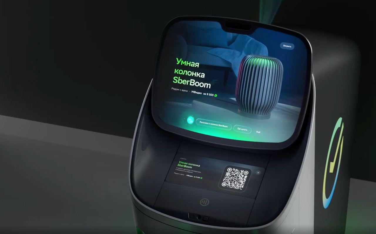 На конференции Сделано в Сбере показали чудо банкомат Нет он не только быстрее предыдущих наличку считать умеет Фишек больше Это скорее многофункциональная станция обслуживания снять внести поговорить с ИИ помощником и одновременно пройти мини чек ап Прикиньте прямо стоя у экрана без манжет и проводов Технологии Просто смотрите в камеру и держите пальцы на специальных датчиках а устройство само анализирует пульс давление уровень стресса и утомления ИМТ предполагаемый холестерин средний уровень глюкозы жесткость артерий и вариабельность сердечного ритма Экспресс оценка здоровья доступна всем старше 18 лет Интерфейс разработан специально под Сбер внутри живет интеллектуальный помощник на базе ГигаЧата Можно общаться с ним голосом и делать базовые операции Скоро банкомату можно будет сказать что то вроде Половину внеси мне на карту ХХХ рублей Очевидно еще и получить консультацию по продуктам Без похода в офис А это они ловко придумали клиент доволен а бизнес оптимизирован