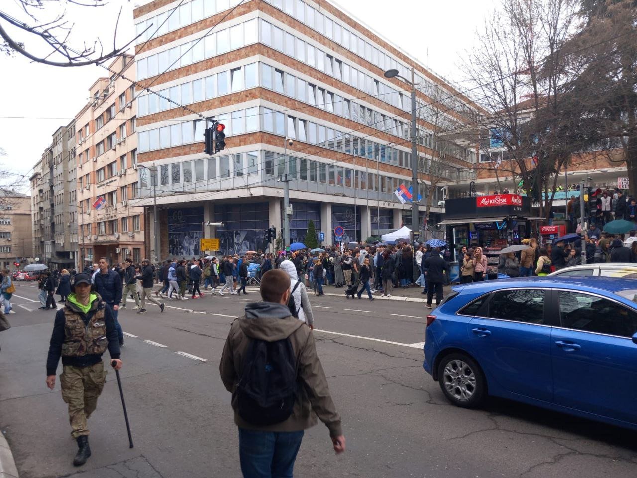 Всего в нескольких сотнях метров от палаточного лагеря сторонников власти на улице Таковской продолжается блокада здания Радиотелевидения Сербии, начавшаяся вчера вечером. Около трёхсот человек заблокировало главный вход в здание РТС. Протестующие свистят и кричат, проезжающие машины поддерживают их сигналами. Участникам акции подвозят еду и воду. Блокада продлится до 21:00.  Фото: Балканист