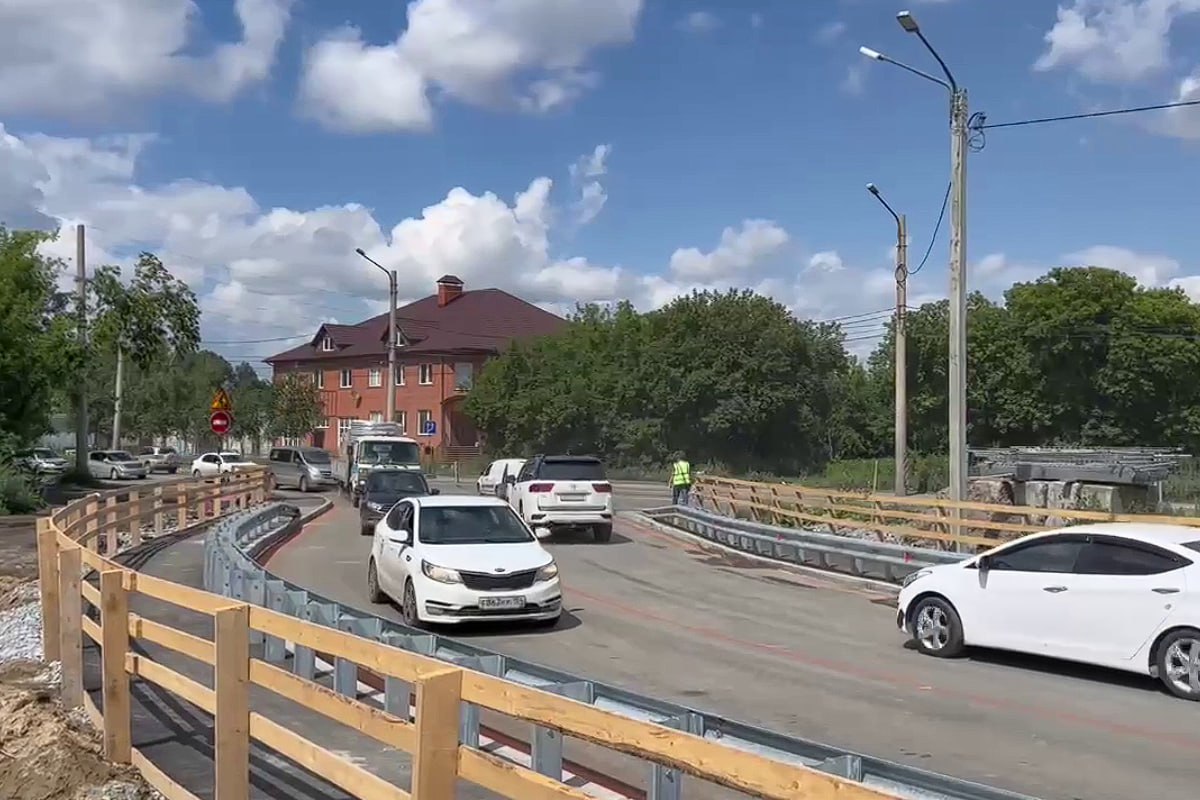 В Новосибирске открылся объезд моста через реку Тулу на улице Петухова На временном мосту уложен асфальт, установлены ограждения и освещение. Благодаря объезду работы на основном объекте будут вести беспрепятственно. В Новосибирске на улице Петухова открылся временный объезд — он будет действовать весь период проведения капитального ремонта моста через реку Тулу на улице Петухова. Подрядчик уложил асфальт, установил ограждение и освещение на новом мосту, им уже можно пользоваться, а на старом мосту начать работы, рассказал мэр Максим Кудрявцев. Мост через Тулу построили в 1962 году, капитального ремонта за шесть десятилетий не было ни разу. Конструкция находится в предаварийном состоянии: ограждения проезжей и прохожей частей недостаточно крепкие, есть прогрессирующие дефекты на пролетных строениях и опорах моста. Кроме этого, проезжей части не хватает ширины, потому пропуская способность моста низкая. Ход работ отслеживают специалисты «Гормоста» и «Дорэксперта». Завершить ремонт планируется в ноябре 2026 года. По итогу проведения ремонта транспортная доступность района вырастет, а дорожное движение станет более безопасным. В Новосибирске всего на ремонте находятся шесть объектов — и это рекордный объем для города. Четыре моста отремонтируют в этом году и два — в следующем, а самый крупный среди объектов — Димитровский мост, построенный в 1978 году.