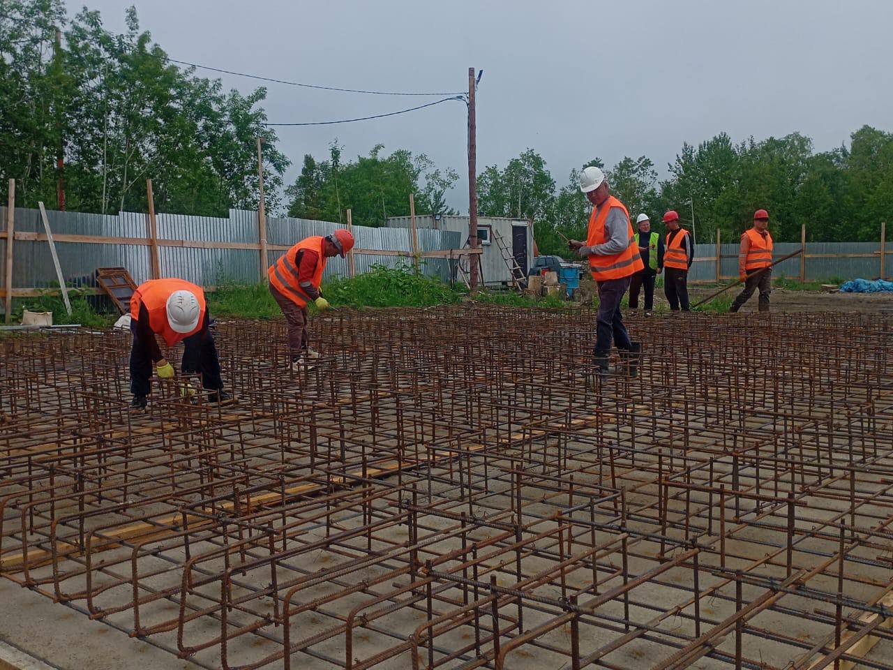 Сразу две газовые котельные строят в Поронайском районе.  Новые теплообъекты появятся в сёлах Леонидово и Гастелло. В последнем работы выполнили уже на 40%. Специалисты заложили монолитный фундамент дымовой трубы и основание под саму котельную. Сейчас работники занимаются его армированием. Предстоит вручную связать 1,5 тонны арматуры. Также подготовили   котлован глубиной 6,5 метров под насосную станцию, где установят две цистерны общим объемом 260 тысяч литров воды. Их уже доставили на стройплощадку. Мощность нового комплекса составит 3 мегаватта. Он заменит устаревшую угольную и дизельную котельные, и обеспечит энергией два многоквартирных дома, клуб, школу, ФАП и здание сельской администрации. Сдать объект и провести пуско-наладочные работы планируют к осени, а запустят котельную в начале отопительного сезона 2026 года.