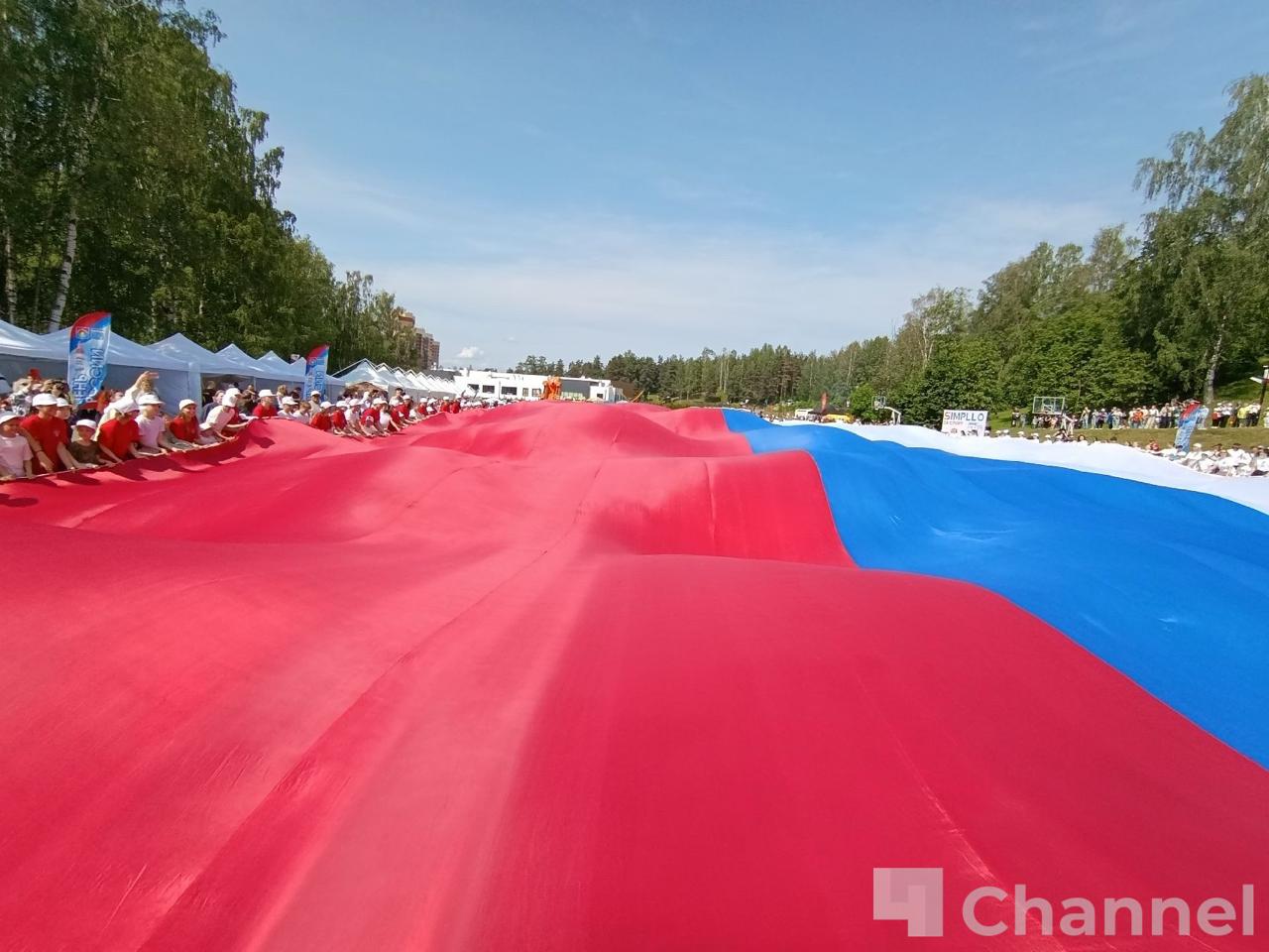 Во Всеволожске развернули огромный флаг России В День России во Всеволожске прошла патриотическая акция «Одно сердце, одна Родина, один флаг». Губернатор Ленинградской области Александр Дрозденко и волонтеры развернули огромный российский триколор. В акции приняли участие 160 ребят. Площадь российского флага, который развернули в парке Песчанка, составила 2 025 квадратных метров. 47channel.ru - о жизни Ленинградской области и не только