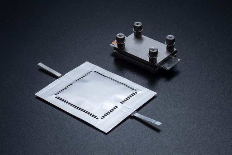 Электричество из воздуха прорыв в создании литий воздушных батарей Японские учёные из Национального института материаловедения NIMS и компании Toyo Tanso сообщили о важнейшем достижении в развитии литий воздушных аккумуляторов преодолев ключевые технические барьеры которые ранее сдерживали внедрение этой технологии такие как низкая выходная мощность быстрая деградация электродов из традиционных материалов сложности создания углеродных электродов с подходящей пористой структурой Литий воздушные аккумуляторы заимствуют кислород для электрохимической реакции прямо из воздуха что значительно снижает их массу и потенциально способны обеспечить энергетическую плотность в разы и даже на порядок превышающую таковую в их лучших литий ионных аналогах приблизив их по удельной энергоемкости к ископаемым видам топлива Благодаря этому технология особенно перспективна для авиации с её жесткими требованиями к весу и габаритам источников энергии Команда исследователей из NIMS представила новый углеродный электрод созданный из мезопористого углеродного материала CNovel разработанного специалистами компании Toyo Tanso с точно контролируемой пористой структурой позволивший создать первый в мире стабильный многослойный литий воздушный аккумулятор ёмкостью свыше 1 Вт ч и размером пластины 4 4 см Ранее основная проблема масштабирования литий воздушных аккумуляторов была связана с крайне сложной задачей создания углеродного электрода с предсказуемой пористой структурой то есть с порами определенного размера необходимого для стабильной работы такой батареи NIMS Постфактум Zuri eVTOL Онлайн проект eMAKS aviasalonmaks