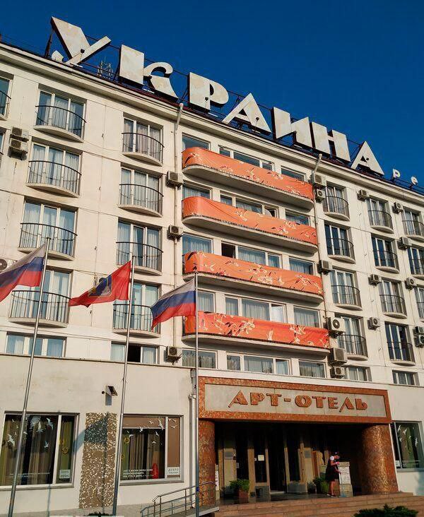 Гостиница «Украина» - минус табличка  С фасада здания сняли название, которое висело там с 1963 года, со дня открытия. За шесть десятилетий оно ни разу не менялось.  И это в стране, где так любят вещать о «священности топонимов» и возмущаться, когда кто-то осмеливается использовать исторические названия. Видимо, чужие таблички трогать нельзя, а свои - можно.  Особенно забавно на фоне их риторики, что, мол, воюют они «не с Украиной», а с «режимом Зеленского и нацистами». Но почему-то даже бездушный бетон гостиницы попал под «денацификацию по-русски».