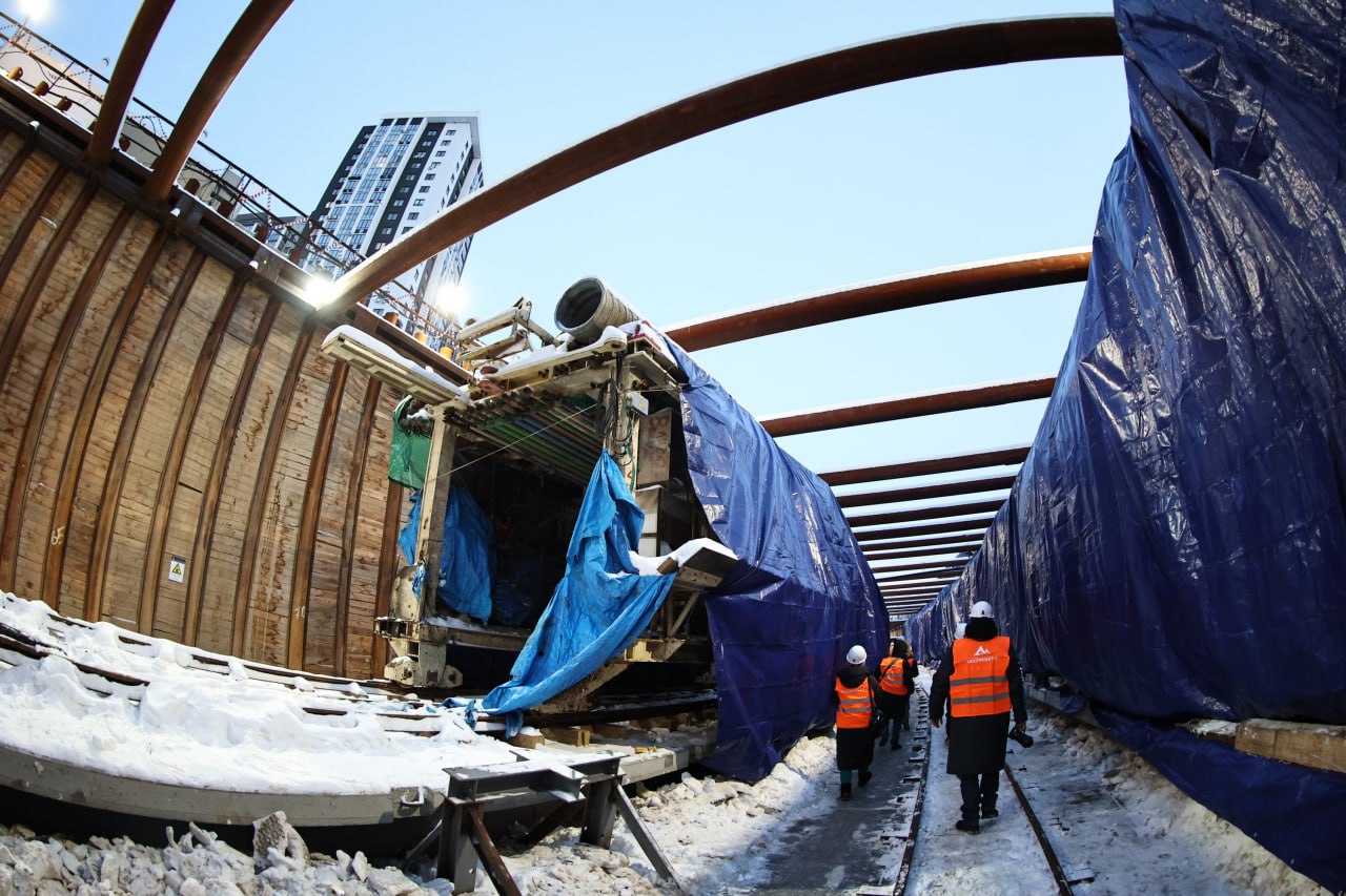 Обустройство котлована для метротрама начали на северо западе Челябинска Рабочие приступили к основному этапу строительства стартового котлована для будущего метротрамвая на проспекте Победы В нем соберут и запустят под землю два тоннелепроходческих комплекса Они начнут прокладывать тоннели линии Север Юг от остановочного пункта Улица Косарева в сторону станции Торговый центр Длина котлована составит 70 метров ширина до 17 метров глубина до 10 метров При разработке котлована предстоит извлечь более девяти тысяч кубометров грунта пояснили в областном правительстве По мере углубления котлована через каждые три метра его стенки будут укреплять при помощи специально разработанной для этого проекта распорной системой Масса конструкции превысит 83 тонны После завершения земляных работ в котловане железобетонный лоток для монтажа тоннелепроходческих щитов Их уже доставили на стройплощадку Подписаться на vecherchel   Поддержать Читать в Мах