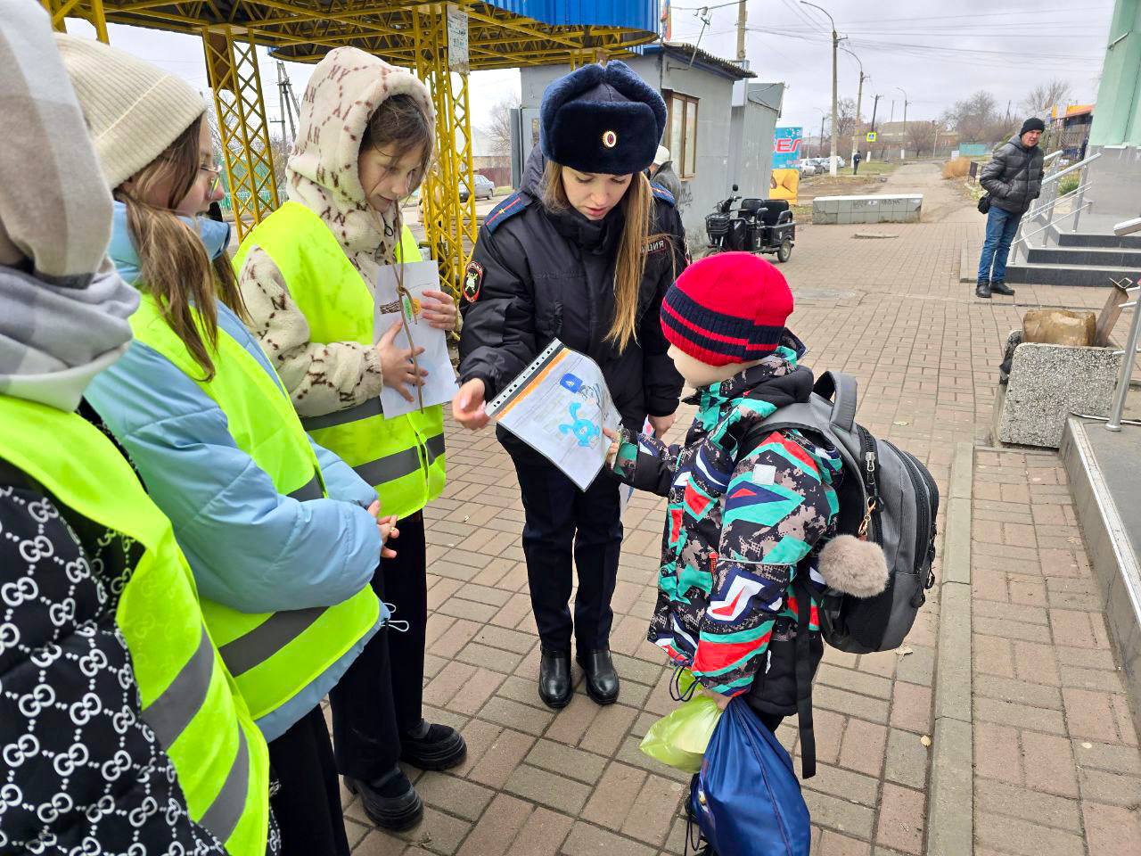 #вРоссиижить — в безопасности быть   Сотрудники Госавтоинспекции ЛНР напомнили жителям Луганска о важности использования световозвращающих элементов   Сотрудники ГИБДД МВД по ЛНР совместно с отрядом «Дозор» Луганской школы № 51, вооружившись световозвращающими брелоками и рисунками детей по тематике безопасного дорожного движения, вблизи школы пообщались с учениками начальной школы и их родителями.  В ходе диалога с ребятами было установлено, что каждый школьник знает, что такое световозвращающие элементы и почему их стоит использовать в темное время суток. Родителям ребят ЮИДовцы рассказали о том, что световозвращающие элементы повышают видимость пешеходов и помогают водителям своевременно реагировать на их присутствие, что, в свою очередь, снижает вероятность наезда и, соответственно, травм пешеходов. Поэтому в данном вопросе важно себя обезопасить, а также уважительно отнестись к водителям транспортных средств, которым сложно увидеть пешехода на дороге без фликера.