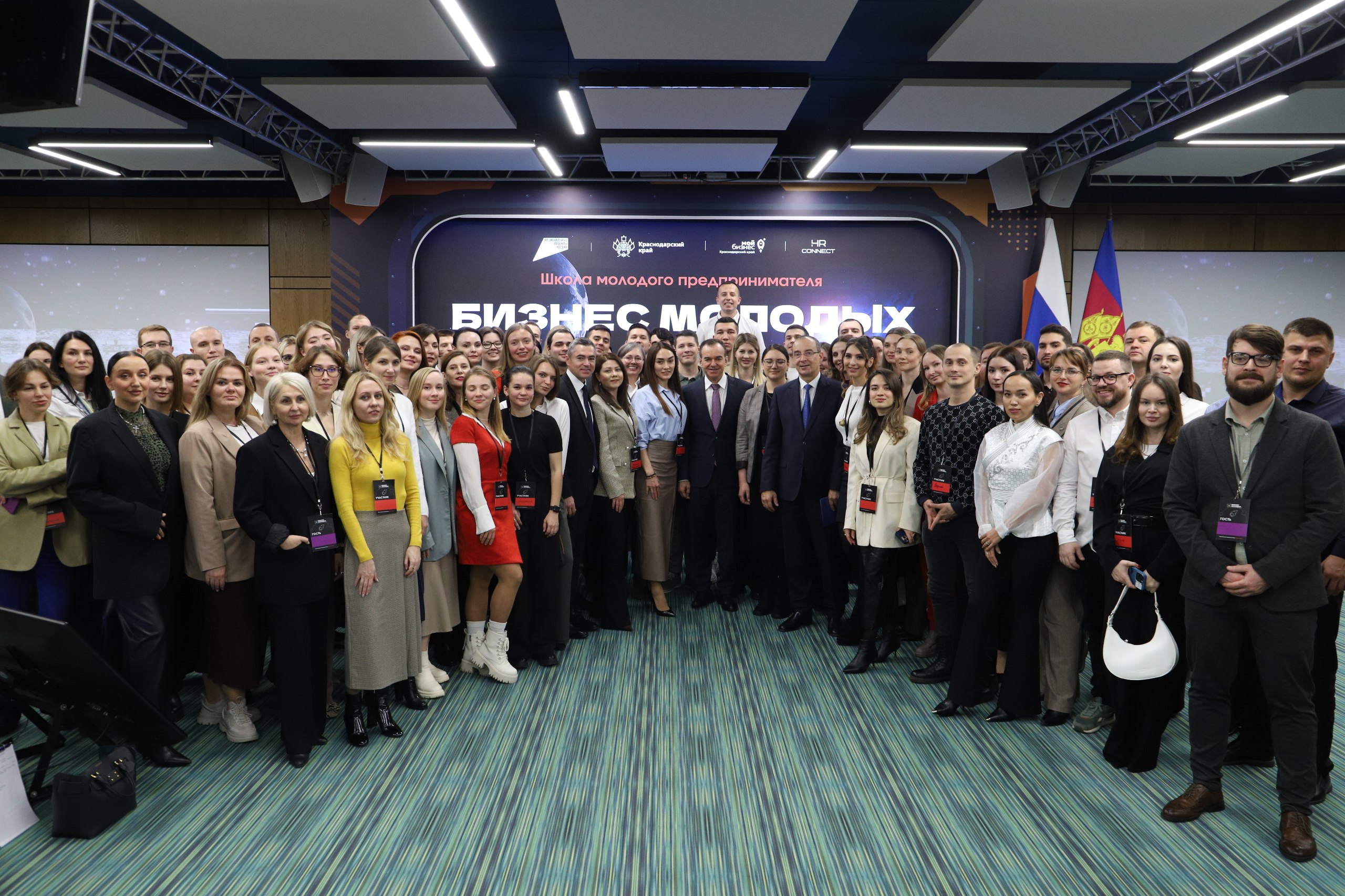 Губернатор Кубани Вениамин Кондратьев и председатель ЗСК Юрий Бурлачко приняли участие в итоговом мероприятии проекта Школа молодого предпринимателя Бизнес молодых В его рамках были подведены результаты выполнения программы за 2021 2025 годы За это время подготовку прошли 12 5 тысячи молодых людей По итогам было создано 2 тыс малых предприятий и более 600 новых рабочих мест зарегистрировано более 3 5 тыс самозанятых Обращаясь к собравшимся глава региона назвал ключевую цель проекта Бизнес это экономика Экономика ваших семей муниципальных образований края и страны И нам важно было не потерять ни одного кто готов и способен заниматься бизнесом Кто в силу своей одаренности чувствует рынок конъюнктуру и спрос кто понимает как сделать предложение и идти на предупреждение ситуации на рынке сказал Вениамин Кондратьев Приветствуя участников мероприятия от имени депутатов Законодательного Собрания руководитель парламента подчеркнул что проектом реализована его главная задача самоопределение молодых людей Бизнес это удел сильных И вы как никто это понимаете На сегодняшний день малый и средний бизнес в структуре экономики занимает более 86 И от успехов каждого из вас зависит экономический успех такого крупного и мощного региона как Краснодарский край акцентировал Юрий Бурлачко Председатель ЗСК добавил что для развития бизнеса в крае действует более 200 мер поддержки В завершение Юрий Бурлачко поблагодарил участников программы за вклад в развитие экономики Кубани а организаторов бизнес тренеров и наставников за реализацию проекта К участникам встречи также обратились вице губернатор Александр Руппель и исполнительный директор Фонда развития бизнеса Краснодарского края Елена Пистунова В ходе мероприятия Губернатор Краснодарского края и председатель ЗСК вручили награды организаторам и финалистам программы