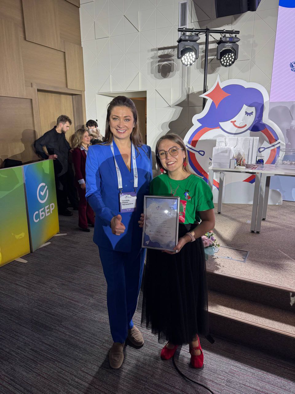 Впервые в истории конкурса Мама предприниматель проект из Чувашии вошел в топ 10 бизнес инициатив Медиакласс Зеленка получил спецприз Минэкономразвития России Мамы предприниматели Оксана Замятина и Ирина Волкова поставили перед собой задачу дать предпрофессиональную подготовку детям 10 17 лет и трансформировать их из потребителей шаблонного видео в авторов осмысленного контента Например медиакласс подготовил креативные ролики ко Дню республики с дверного форума Победителем же федерального конкурса стал проект из Самарской области где открыли производство по пошиву адаптивной одежды для детей с особенностями развития