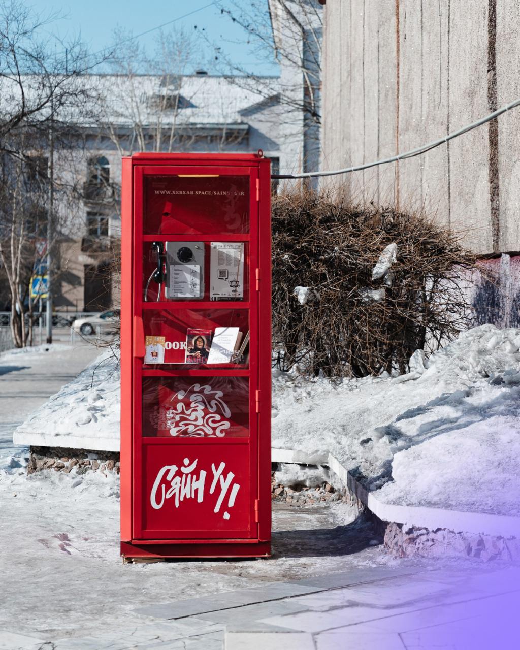 При поддержке ВЭБа в Улан-Удэ открыли телефонную будку историй «САЙНУУ! ГЭР  ДОМ » 7    Теперь любой желающий может услышать истории города через трубку классического дискового телефона.   4   Арт-объект предлагает 137 аудиоисторий на русском и бурятском языках, которые можно послушать, набрав их номер на аппарате:    97 из них — воспоминания жителей Улан-Удэ, представителей разных профессий, возрастов и интересов;   40 — рассказы о Национальном музее Бурятии и театре песни и танца «Байкал».   Также в будке есть полка для буккроссинга, где где любой желающий может обменять книги. Яркий дизайн делает объект привлекательной фотозоной для жителей и туристов.  Ранее каталог проекта «САЙНУУ! АРТ» признали лучшим полиграфическим изданием Бурятии.