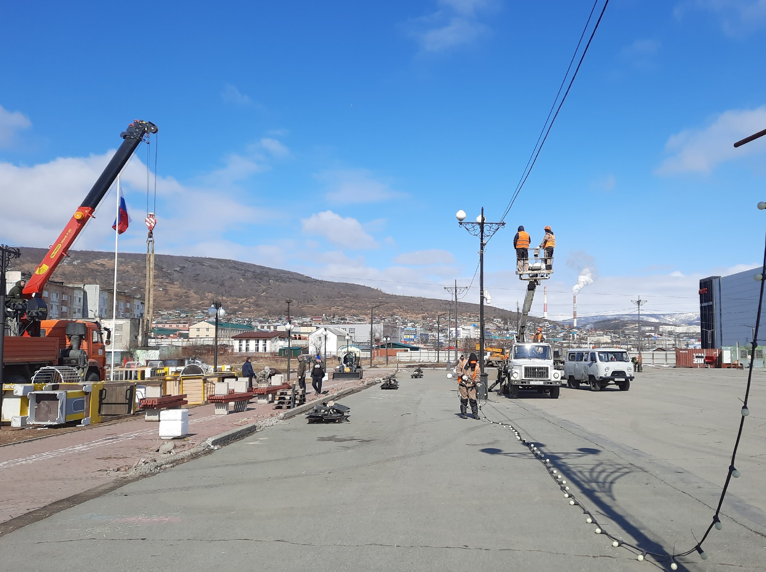 На Магаданской площади стартовали работы по демонтажу старого оборудования и дальнейшему благоустройству территории. На объекте трудятся специалисты городских служб: Горсвета, Комбината зеленого хозяйства, ГЭЛУДа. Они демонтируют детский городок, опоры наружного освещения, линии электропередачи, бордюры, убирают асфальтовое покрытие. Работы по демонтажу продолжатся до начала июня, после чего на объект выйдет подрядчик – ООО «Магстрой», который займется благоустройством площади. Реализация проекта намечена на 2025-2026 годы. Главные акценты реновации территории – современная транспортная и пешеходная логистика, детские игровые локации, освещение и озеленение, открытие фуд-зоны. Преображение популярного общественного пространства стало возможно благодаря реализации нацпроекта «Инфраструктура для жизни», который продолжает ранее действовавший национальный проект «Жилье и городская среда». #Магадан #Благоустройство #НацпроектИнфраструктураДляЖизни