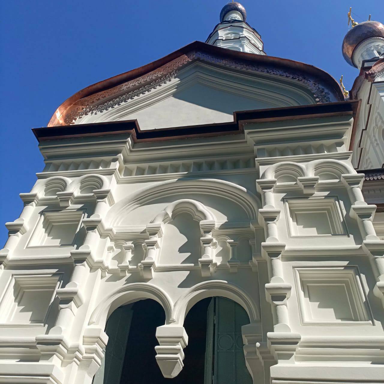 Завершена реставрация фасадов Казанской церкви в Зеленогорске на Приморском шоссе, 547   Работы выполнены по программе КГИОП за счет бюджета Санкт-Петербурга.  Белоснежная многоглавая церковь с высокой колокольней является визитной карточкой Зеленогорска.   В ходе работ поверхность фасадов церкви расчищена от поздних цементных накрывок, отреставрирован исторический штукатурный слой и декоративные элементы киотов, кокошников, закомар и карнизов.   На гранитной облицовке цоколя, сильно пострадавшей в период Великой Отечественной войны от взрывов, в местах утрат камня выполнены гранитные вставки, произведён ремонт трещин и герметизация швов.   Отреставрирована главная входная дубовая дверь с фрамугой.   Проведены реставрация, воссоздание и усиление стропильной системы, заменена обрешётка. На всех десяти главках церкви отреставрированы исторические журавцы и заменены крестонесущие столбы.    В чётком соответствии с исторической иконографией, выполнены и вызолочены десять крестов.    Над апсидой восстановлено историческое окрытие кровли из меди «в шашку». Крыши, линейные окрытия и главки церкви из специальной кровельной меди в процессе эксплуатации покроются естественной патиной, которая придаст им характерный исторический облик и защитит поверхность.   Завершаются работы по восстановлению штукатурки внутренних исторических откосов окон.    Подробнее о проведенных работах и истории церкви – на сайте КГИОП.  #КГИОП_реставрация