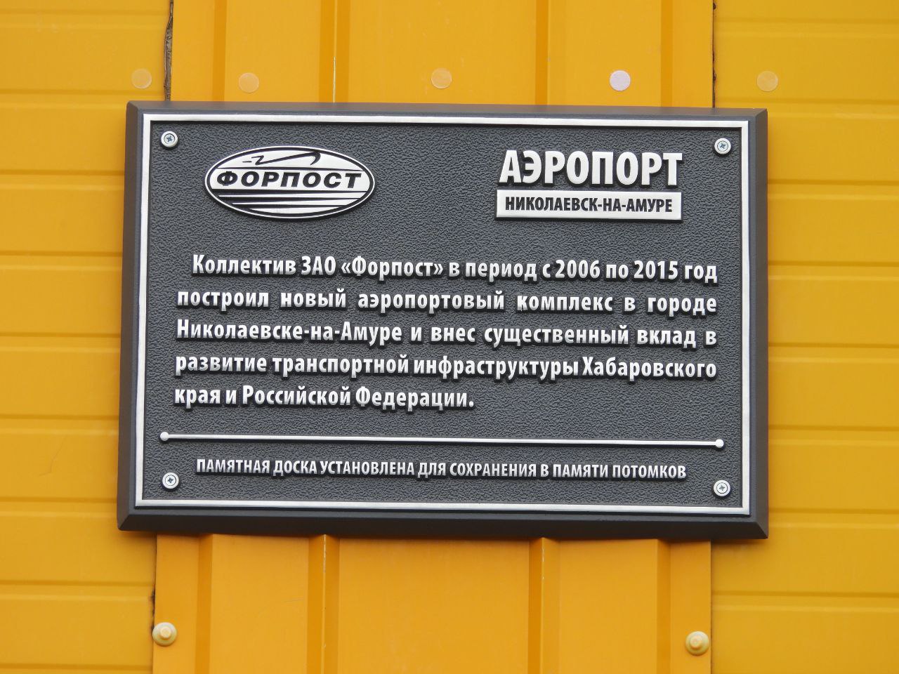 Памятную доску установили на фасаде здания аэропорта в Николаевске-на-Амуре  В преддверии Дня строителя на фасаде здания аэропорта в Николаевске-на-Амуре появилась памятная доска его строителям.   Строительство аэропорта началось в 90-х годах прошлого столетия, но, в силу многих причин, было приостановлено. Лишь весной 2006 года Росавиацией был объявлен конкурс на выбор генерального подрядчика по строительству аэропорта, включая всю инфраструктуру. Победителем конкурса стало ЗАО «Форпост».  Объект был принят в эксплуатацию в октябре 2014 года.  Торжественная церемония открытия нового здания проходила в дни празднования 165-летия со дня основания г. Николаевска-на-Амуре в 2015 году.  Фото/видео администрации Николаевского района   AmurMedia    Прислать новость