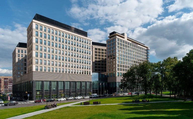 ВТБ нашел покупателя на гостиничный комплекс Hyatt Regency Moscow Petrovsky Park рядом с метро Динамо Новым владельцем отеля на 298 номеров стало АО Петровский парк отель свидетельствуют данные Росреестра Компания собственники которой не раскрываются находится под управлением 360 EHM Эта структура работает на рынке недвижимости с 2018 года Она управляет объектами в различных регионах России в ее портфеле пятизвездочные отели в Москве Санкт Петербурге и Геленджике а также бизнес центр в Нижнем Новгороде В ВТБ информацию о продаже отеля подтвердили но другие детали раскрывать не стали Сейчас рыночная стоимость объекта составляет порядка 8 10 млрд руб полагают эксперты Фото Евгений Васильев Shutterstock Читать РБК в Telegram