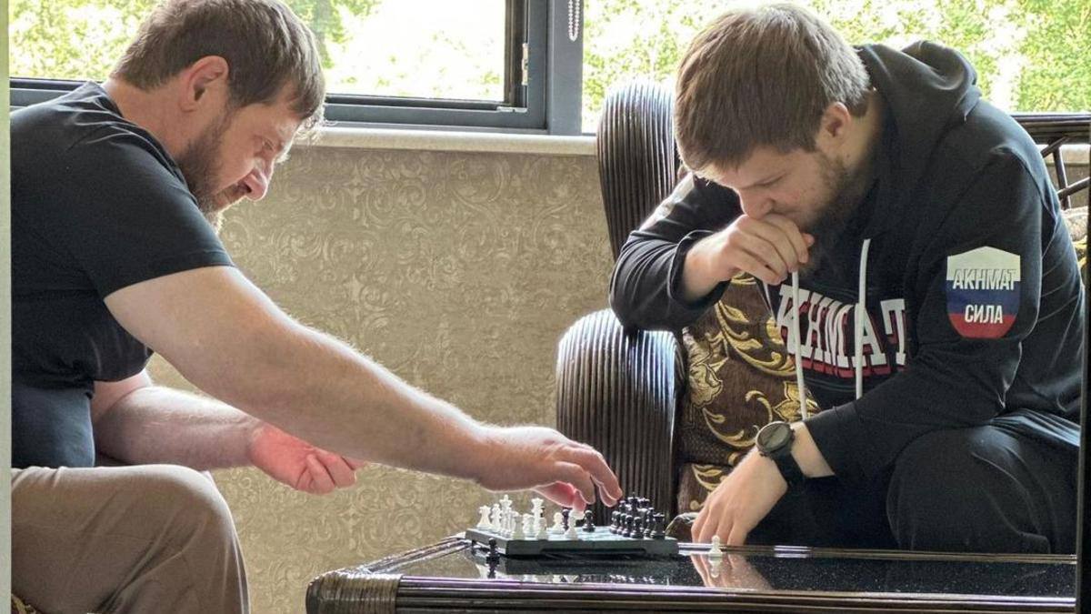 Опубликована первая фотография Рамзана Кадырова после истории о его госпитализации в Турции  На ней глава Чечни проводит «товарищеский матч по шахматам с министром спорта и физической культуры Чеченской Республики». Если проще — со своим 19-летним сыном Ахматом Кадыровым.  «Дебют выдался довольно острым, с активным разменом фигур, хотя и играли без ограничения времени. Ну и, конечно же, я выиграл», — прокомментировал фото Кадыров. Он добавил, что теперь оба участника будут готовиться к реваншу.  Ахмат Кадыров уже закрепил за собой звание самого молодого министра в новейший истории России. Слухи о госпитализации его отца в турецком Бодруме появились в СМИ 24 июля. Известно, что в последующие дни глава Чечни ни разу не появлялся на публике.  Это Борус