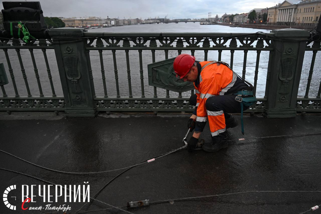 Мосты к празднику готовы: Дворцовый и Троицкий подготовили к «Алым парусам» В ночь на 25 июня специалисты Энергохозяйства ГЭТ подготовили Дворцовый и Троицкий мосты к пиротехническому шоу «Алых парусов». С Дворцового демонтировали контактную сеть троллейбусов, на Троицком — временно отключили её без разборки. Всего сняли 320 метров проводов и 600 метров троса. Работы прошли ночью, с сохранением движения транспорта. Обратный монтаж начнётся после 29 июня, когда город отпразднует главный выпускной года. Фото: Александр Гальперин Вечерний Санкт-Петербург