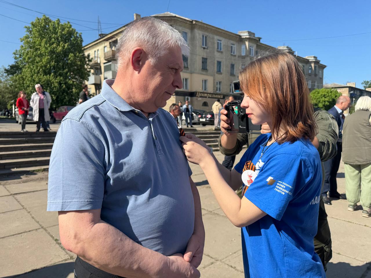 В ЛНР при поддержке «Единой России» продолжаются уличные концерты «Марш Победы» В малых населенных пунктах ЛНР при поддержке Луганского регионального отделения партии «Единая Россия» и депутата Госдумы РФ Виктора Водолацкого продолжается акция «Марш Победы». В рамках акции в городах и поселках проводятся уличные концерты, приуроченные к 80-летию Победы в Великой Отечественной войне. Артисты ансамбля песни и пляски Центрального военного округа и народного театра песни «Непоседы» накануне побывали в Станично-Луганском районе, а 4 мая выступили в Славяносербском районе - городе Зимогорье и селе Хорошее. Творческие коллективы спели песни Победы со сцены «КАМАЗа» на центральных площадях населенных пунктов. Один из организаторов выездного концерта, первый заместитель Секретаря Луганского регионального отделения партии «Единая Россия» Василий Леонов отметил, что акция «Марш Победы» призвана подарить людям праздничное настроение и поднять их патриотический дух в преддверии празднования годовщины Великой Победы. - 9 Мая – для нас это праздник, который не вырвать ни из сердца, ни из разума. Мы не можем понять, как можно забыть о подвиге своего народа. Хочется сказать огромное спасибо командованию Центрального военного округа, лично командующему, ансамблю песни и пляски Центрального округа, а также детям из нашего творческого коллектива «Непоседы» за то, что они делают такие мероприятия совместно с нами. Пока есть в наших сердцах искра Победы, пока жива память великого народа мы побеждали и будем побеждать на всех фронтах, - подчеркнул Василий Леонов С наступающим праздником жителей поздравила также секретарь Славяносребского местного отделения «Единой России» Светлана Гизай. Жители с удовольствием вместе с артистами пели знакомые с детства песни. - Мы шли с внучкой в магазин и увидели такую радость. Думали, остановимся на пять минут, а задержались на час. Так хорошо все пели, даже на душе легче стало. Спасибо тем, кто придумал для нас такую радость, - рассказала жительница Зимогорья Валентина Фёдоровна. Отметим, что после концертов всех желающих угощают праздничным кулешом. #ЕдинаяРоссия #ЕР81 #80ЛетПобеды #МаршПобеды