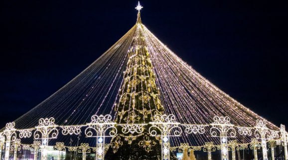 В Великом Новгороде начали собирать 21-метровую новогоднюю ель  В столице Новгородской области началась подготовка к Новому году. На площади Победы-Софийской приступили к установке новогодней ели. Мастера приступили к установке 21-метровой ели, состоящей из 30 ярусов. Новогоднее дерево купили на аукционе. Ель обошлась городу в 2 миллиона 790 тысяч рублей. Это ниже начальной цены на 1 миллион 300 тысяч рублей. Предыдущее дерево прослужило новгородцам пять лет, уточнили представители власти. Ель украсят 800 сверкающих шаров красного, золотого и серебристого цветов.