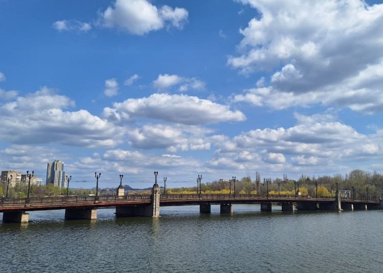 С 17 мая часть моста на проспекте Ильича будет перекрыта До сентября 2025 года будут перекрыты две из четырех существующих полос движения, после – полное закрытие моста до окончания работ в конце 2026 года. Специалисты подрядной организации «Мостовик» заменят старые опоры и пролетные строения на новые. При реконструкции сохранится исторический облик моста. Также будет возведен временный технологический мост, с которого будут осуществляться демонтаж аварийного сооружения и возведение нового моста. Данный технологический мост будет предназначен только для движения по нему спецтехники Отмечается, что до начала демонтажа моста будут вынесены коммуникации, проходящих по мосту газопровод, водопровод, электрические силовые кабеля и сети связи , методом «прокола» по руслу реки Кальмиус.