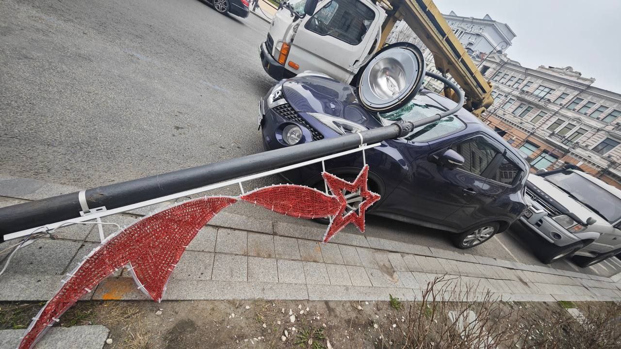 Во Владивостоке на улице Светланской штормовой порыв ветра опрокинул столб на припаркованную машину Источник: Вести:Приморье