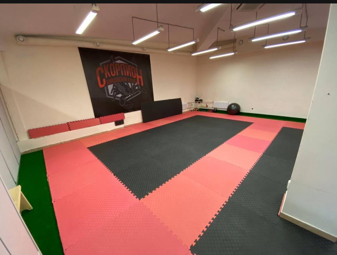 Когда спорт становится причиной головной боли: прокуратура потребовала закрыть небезопасный детский спортивный клуб «Скорпион» Прокуратура проверила красноярский детский бойцовский клуб «Скорпион» на улице Шумяцкого и выяснила, что тренировки у ребят в офисном здании ведет самозанятый спортсмен. Тренер краевой сборной решил стать предпринимателем и посчитал это место идеальным для подготовки будущих чемпионов по кигбоксингу. Помещение в 260 кв. м обеспечено светом и теплом, однако находится в подвале. Единственный эвакуационный выход не ведет на улицу — он загроможден спортивным инвентарем. В тренировочных залах одновременно находится не менее 25 человек, но средства пожаротушения не предусмотрены, системы противопожарной защиты не продуманы. Не возражая против здорового образа жизни, прокуратура заявила иск о запрете эксплуатации подвального помещения в качестве спортивного клуба. Суд принял решение остановить его работу, как итог, аренда не стала долгосрочной. Контроль за переездом тренировочного процесса остается за прокуратурой. Сайт Тelegram ВК
