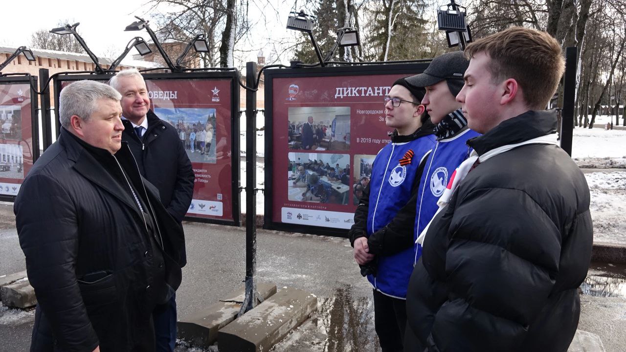 В Великом Новгороде открылась фотовыставка о «Диктанте Победы»  В Великом Новгороде открылась фотовыставка просветительской акции «Диктант Победы», посвящённая истории, географии площадок и знаковым местам написания Диктанта в стране. У входа в Кремль на площади Победы-Софийской размещены 10 стендов с 20 фотоплакатами, рассказывающими об этой акции. Несколько из них посвящены проведению Диктанта в Новгородской области. В открытии экспозиции принял участие врио губернатора Новгородской области Александр Дронов.  «Диктант Победы» пройдёт 25 апреля в 12:00 по всей России и ещё в 80 странах мира. В Новгородской области он состоится уже в шестой раз. Цель акции - вызвать интерес к событиям героического прошлого страны, а заодно проверить знания и узнать о подвигах своих предков во время Великой Отечественной войны. В этом году будет работать почти 180 площадок проведения диктанта.