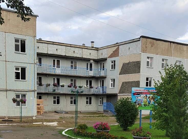 Территория детского сада в Кедровом небезопасна для детей, но местная администрация бездействует.  Родители дошколят в Кедровом устали просить ответственных чиновников привести в порядок территорию единственного детского сада «Росинка». Вот уже несколько лет вокруг учреждения не могут положить асфальт, территорию отсыпают щебнем. Маленькие дети постоянно спотыкаются, запинаются и зачастую вовсе падают. А во время таяния снега или дождей территория становится просто непригодна для прогулок. Дошколята часто остаются в помещении, а не играют на свежем воздухе. Кроме того, состояние крылец эвакуационных выходов крайне плачевное, недавно перед одним из них образовалась дыра.  Регулярные обращения родителей и заведующей детского сада к местным чиновникам остаются без внимания. Неоднократно они обращались и к главе посёлка Кедровый Валентину Дюбину, он в курсе проблемы. Только вот почему-то кроме обещаний ничего родители так и не увидели.  У людей возникает справедливый вопрос, почему в других районах и населенных пунктах средства на капитальный ремонт детских садов и школ находят, а их чиновники не могут справиться с единственным детским садом и одной школой? Почему из-за бездействия администрации место, которое в свете политики государства, особо оберегающей материнство и детство, вместо современного учреждения превращается в одно из самых заброшенных зданий посёлка?  Активисты родительского комитета обратились к координатору ЛДПР в Кедровом Анастасии Казе. Она помогла составить официальное обращение на главу фракции ЛДПР в Законодательном собрании Красноярского края Алексея Бойкова. Депутатские запросы от него уже поступили в краевую прокуратуру, Роспотребнадзор и региональное министерство образования. Будем следить за ситуацией.
