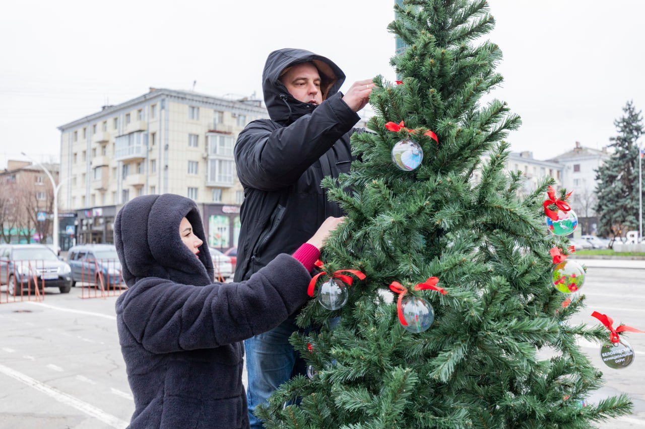 Алчевск, Антрацит, Беловодск и Краснодон уже вовсю наряжают свои ёлочки на Театральной площади Луганска.  Напомним, в этом году вокруг главной ёлки вырастет целый хоровод из 27 ёлочек поменьше — каждая представляет свой округ ЛНР.   Все маленькие ёлочки будут наряжены в своём стиле, отражая историю и традиции района.   На веточках можно будет увидеть украшения с местной символикой, достопримечательностями и даже игрушки, сделанные руками детей и народных умельцев.  Все эти ёлочки будут соединены с главной красавицей одной большой сверкающей гирляндой.    — ждём красоту.  Прислать новость     Подписаться