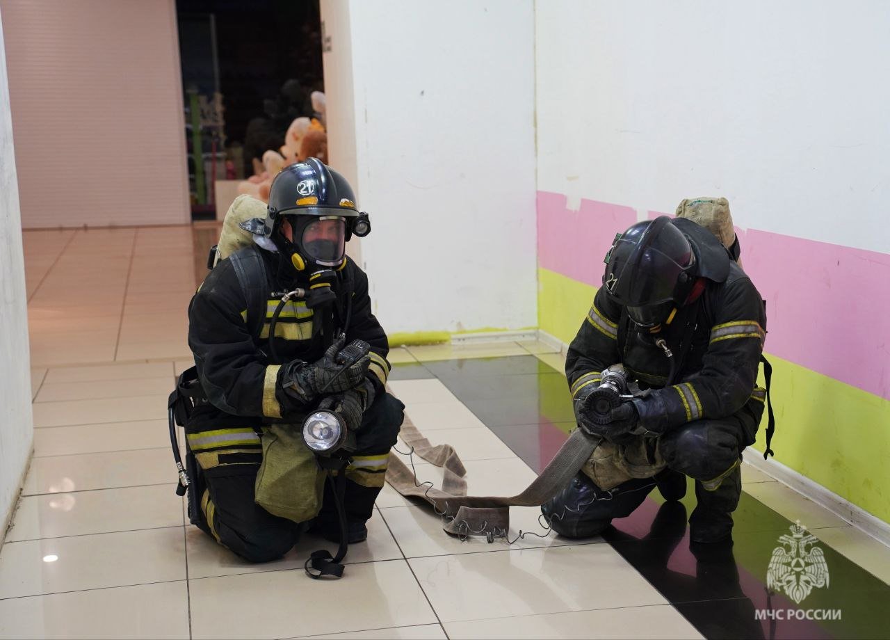 В торговом центре Балакова на проспекте Героев прошли пожарно-тактические учения     Согласно легенде, пожар возник на третьем этаже объекта, в батутном центре. Едкий дым быстро распространился по трехэтажному зданию, что создало опасную ситуацию для посетителей и персонала.    Площадь условного ЧП составила 300 квадратных метров. В дыму пожарным предстояло найди двух условно пострадавших.   Учения включали совместную отработку действий как персонала торгового центра, так и пожарно-спасательных подразделений по тушению огня, эвакуации и спасению людей.    По словам Рустама Биктагирова, начальника службы пожаротушения 1 пожарно-спасательного отряда, подобные объекты требуют реагирования оперативных служб по повышенному номеру вызова. В здании есть фудкорт, детская площадка, батутный центр, цокольный этаж, много торговых помещений. Всё это создаёт дополнительную пожарную нагрузку. Все эти моменты отрабатываются на учениях.