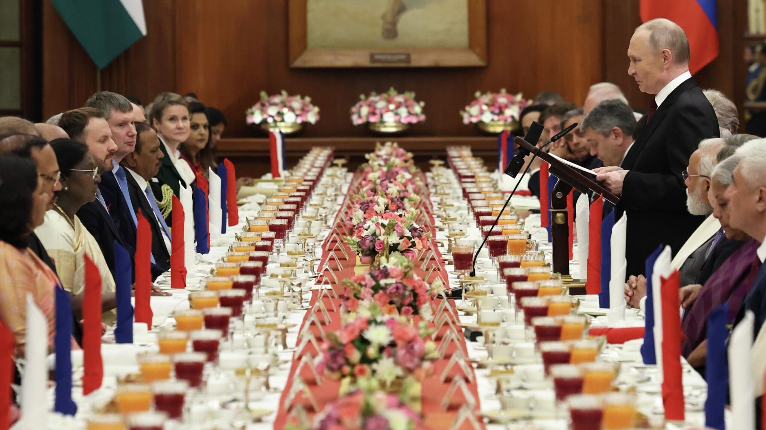 Президент Индии Драупади Мурму угостила президента России Владимира Путина вегетарианским ужином следует из меню ужина полученного РИА Новости В качестве первого блюда был подан легкий бульон из листьев моринги и бобов мунг приправленный специями и украшенный просом На закуски были поданы фаршированные сморчки с чатни из грецких орехов кебабы из черного нута с мятным соусом и паровые пельмени в стиле момо с овощами и водяным орехом В качестве основного блюда были предложены рулет из панира с сухофруктами в шафрановом соусе тушеный шпинат пажитник и свежий горошек в пряной горчичной заправке запеченный в тандуре фаршированный картофель с йогуртово пряным маринадом и мини баклажаны в сладко пряном соусе Также на ужин предлагались тушеные с томатом и луком бобы и рис бамати томленый с орехами и шафраном На десерт были представлены теплая миндальная халва с поджаренными орехами и индийское мороженное с шафраном фисташками и кардамоном