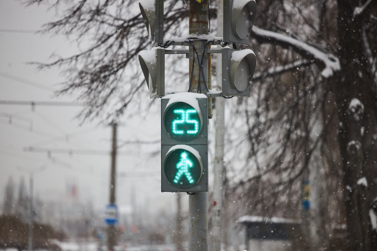 В центре Якутска светофоры заработали в новом пешеходном режиме В Якутске запустили пилотный проект для безопасности людей на дорогах На четырех оживленных перекрестках ввели специальный пешеходный режим работы светофоров Новая схема действует на пересечениях улиц Петра Алексеева с Пояркова и Орджоникидзе а также Лермонтова с Кирова и Свердлова В определенную фазу светофор полностью останавливает весь транспорт а для пешеходов одновременно загорается зеленый сигнал на всех направлениях Это позволяет людям безопасно переходить дорогу даже по диагонали исключая риск столкновения с машинами Данные перекрестки были выбраны не случайно они относятся к местам с высокой концентрацией аварий Решение о тестировании такого режима было принято городской комиссией по безопасности дорожного движения Эксперимент продлится до конца января после чего власти оценят как нововведение повлияло на безопасность и транспортный поток Горожан просят учитывать изменения при планировании поездок и прогулок Фото Оберемченко Николай