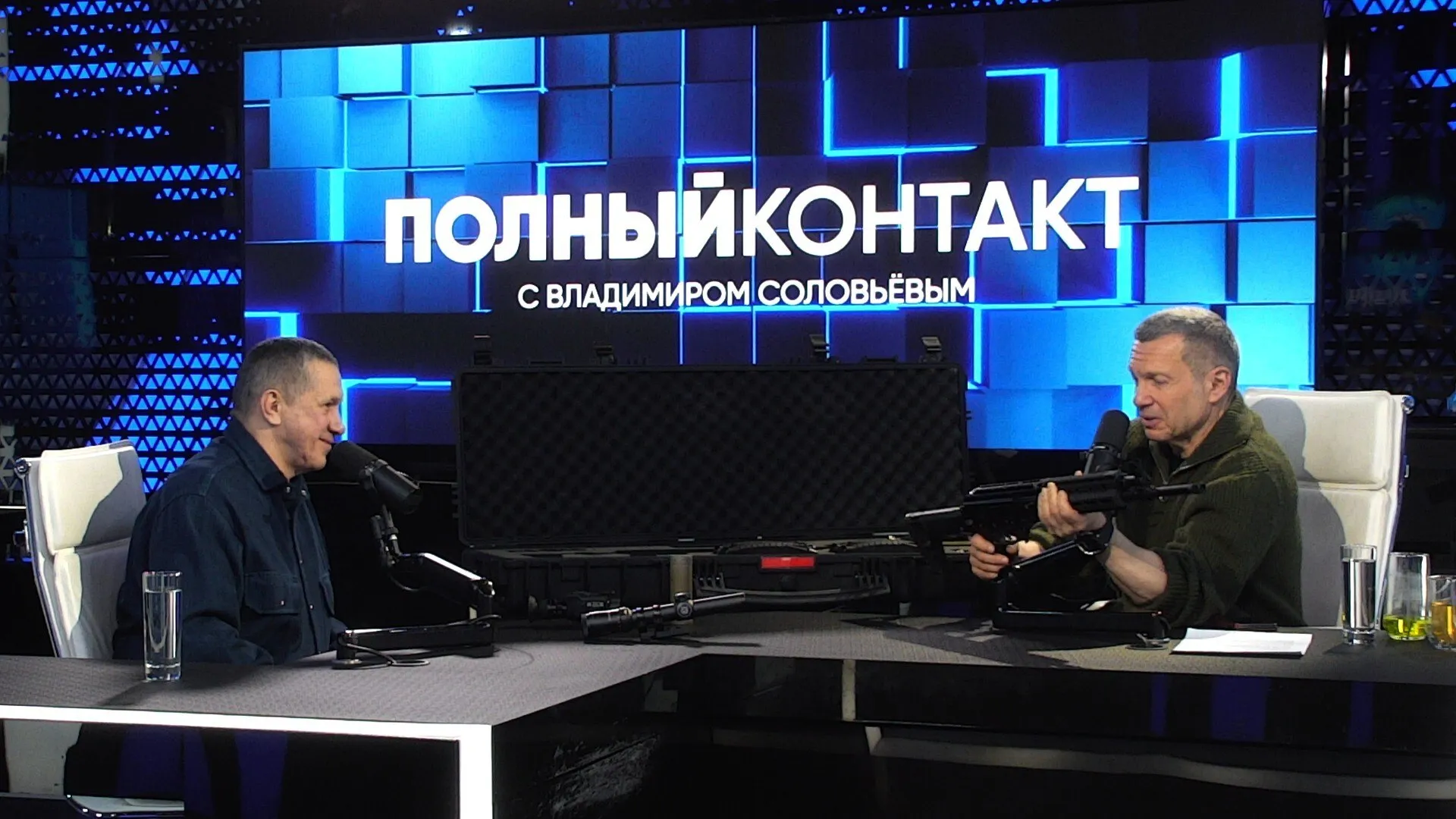 Полпред ДФО Юрий Трутнев представил модернизированный автомат Калашникова и рассказал о подготовке молодежи в центре ВОИН Заместитель Председателя Правительства РФ полномочный представитель Президента РФ в ДФО Юрий Трутнев в эфире программы Полный контакт с Владимиром Соловьевым раскрыл детали разработки усовершенствованной версии автомата Калашникова адаптированной под современные требования боевых действий а также подвел итоги работы Центра военно спортивной подготовки и патриотического воспитания ВОИН В ходе беседы Юрий Трутнев продемонстрировал образец стрелкового оружия созданный совместными усилиями экспертного сообщества ветеранов СВО и специалистов концерна Калашников Я готовился к очередной поездке в зону боевых действий Я проводил тренировку на полигоне с Colt AR 15 Закончилось это тем что было три задержки Я отдал винтовку товарищам и сказал я больше эту штуку в руки не возьму Начали смотреть как мы готовы с точки зрения русского оружия Понятно что в базе наш великий оружейник Михаил Тимофеевич Калашников Но во что уперся взгляд Машина не подготовлена для работы по сегодняшним требованиям отметил Юрий Трутнев Ключевой задачей модернизации стало повышение точности и эргономики без существенного увеличения стоимости Инженерной группе удалось добиться кардинального улучшения показателей кучности стрельбы благодаря оптимизации конструкции ствола демонтирования крепления для штык ножа и интеграции современной оптики Автомат оснащается отечественным прицелом переменной кратности Дедал и тепловизионным оборудованием что позволяет бойцу эффективно работать в любое время суток без дополнительных вложений из личных средств В базовом варианте АК 12 работает с разбросом почти пять угловых минут так что даже на 300 метров из него стрелять уже сомнительно Новая машинка дает полторы угловых минуты а с хорошим боеприпасом выходит на 0 7 0 9 угловых минут Это практически снайперский вариант Я ставил задачу чтобы на 500 метров машинка попадала в голову И она попадает подчеркнул Юрий Трутнев Юрий Трутнев также сообщил что новинка уже получила высокую оценку заместителя Министра обороны РФ Александра Санчика который запросил первую партию для передачи в войска Отдельной темой разговора стала деятельность Центра ВОИН созданного по поручению Президента России Владимира Путина Юрий Трутнев отметил критическую важность системной начальной военной подготовки молодежи Мы знаем что у нас молодежь уже 30 лет не обучается военному делу И это на мой взгляд ни в какие ворота не лезет Поэтому мы с Сергеем Кириенко обратились к Президенту Российской Федерации Он нас поддержал отметил полпред На сегодняшний день Центр ВОИН развернул работу в 21 регионе страны Подготовку прошли уже более 120 тысяч курсантов Ключевым фактором успеха Юрий Трутнев назвал кадровый состав занятия ведут около 400 инструкторов подавляющее большинство которых имеют личный опыт боевых действий и участия в специальной военной операции В завершение беседы стороны затронули необходимость совершенствования законодательства в сфере оборота оружия Юрий Трутнев поддержал позицию Владимира Соловьева о целесообразности упрощения доступа к короткоствольному и нарезному оружию для офицеров и бойцов вернувшихся из зоны боевых действий и имеющих государственные награды