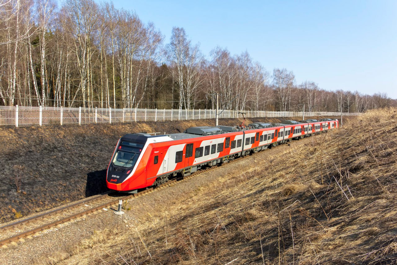 Завершена приемка двухсистемного электропоезда ЭС105 «Финист» Заседание приемочной комиссии состоялось на заводе «Уральские локомотивы». Как сообщает Группа Синара, составу присвоена литера О1 и к производству определена установочная партия из 60 электропоездов. Получение сертификата на серийный выпуск ожидается к июлю. ЭС105 является развитием платформы поездов «Финист» и предназначен для эксплуатации на линиях постоянного и переменного тока. В испытаниях с ноября-2024 принимали участие два пятивагонных состава, что, как заявляют в Группе Синара, позволило проверить их работу в сдвоенном режиме. В линейке подвижного состава «Уральских локомотивов» новый поезд заменит двухсистемные «Ласточки» моделей ЭС1 и ЭС1П, выпускавшиеся ранее совместно с Siemens. Как сообщает производитель, в поезде будет 386 посадочных мест, а также вырастет количество мест для пассажиров с ограниченными возможностями. В феврале в РЖД сообщали, что закупка ЭС105 включена в планы перевозчика. Фото: VadimZD/railgallery