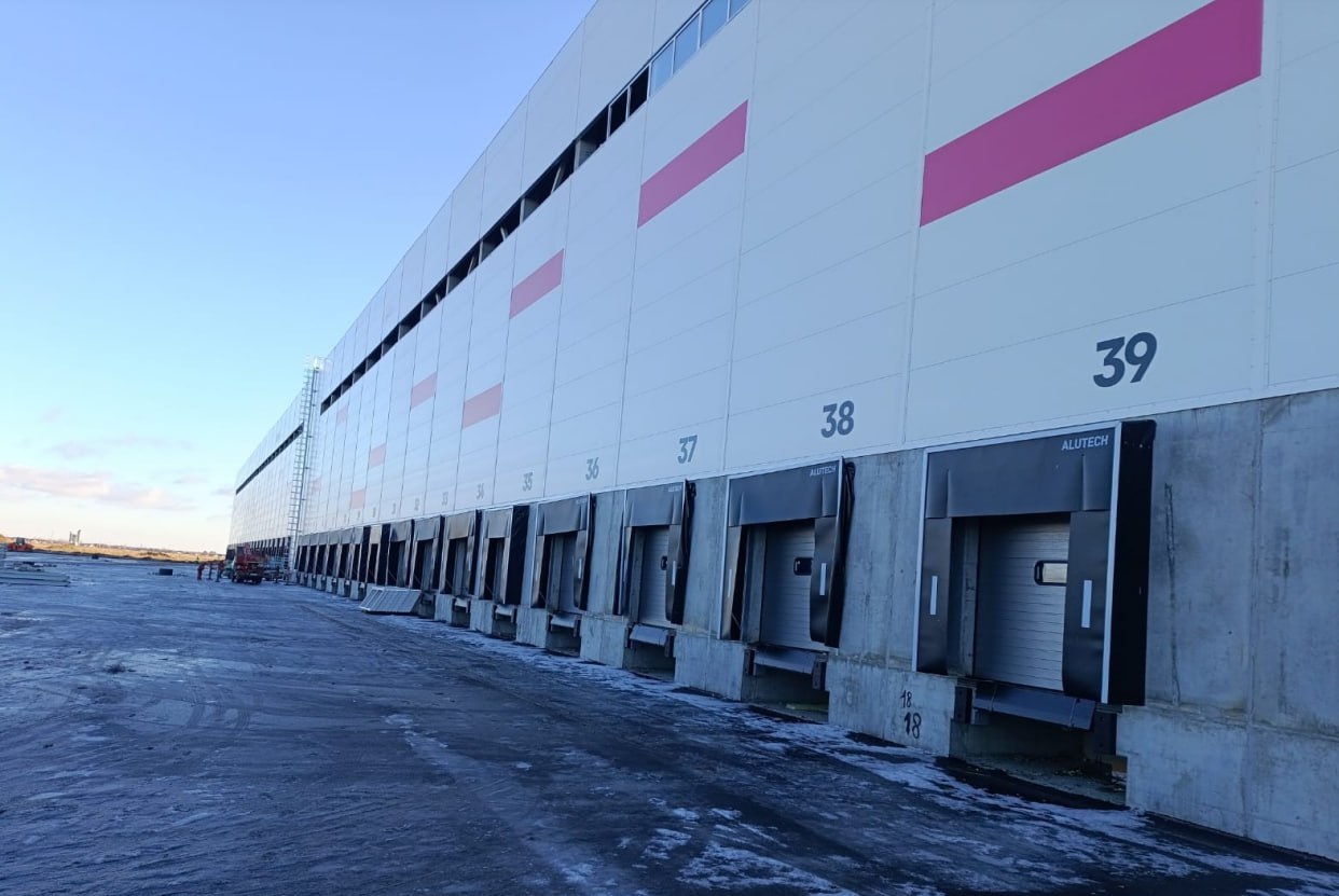 Первую очередь сдали до конца года под Омском заработает логистический центр Wildberries Под конец 2022 го анонсировали строительство распределительного центра Wildberries в селе Троицкое Омского района Спустя три года работа над первой очередью как сообщили в пресс службе объединенной компании Wildberries Russ подошла к концу Разрешение на ввод в эксплуатацию уже получено в ближайший месяц комплекс начнет работать на год позже чем планировалось изначально Первая очередь логоцентра площадью 56 тысяч квадратов позволит хранить 20 млн единиц товаров одновременно Весь комплекс площадью уже 120 тысяч кв м обещают сдать в 2026 году Инвестиции в проект ранее оценивались в 8 млрд рублей Теперь омичи будут тратить деньги получать свои товары еще быстрее Рады Фото Госстройнадзор Омской области Написать в редакцию можно здесь gorod55ru