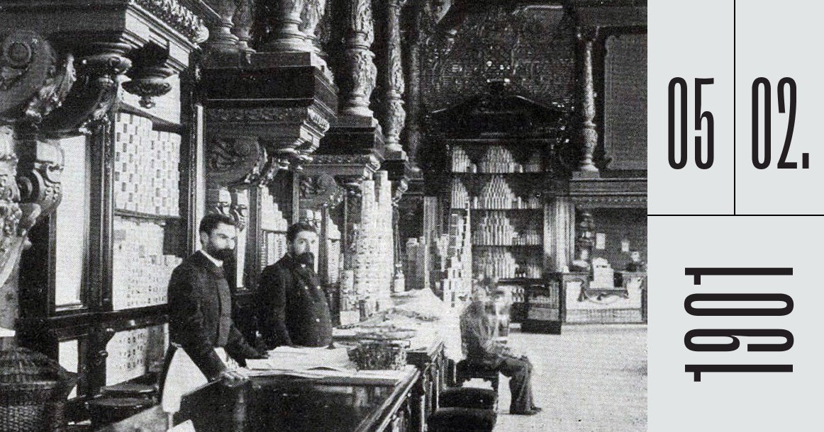 Ровно 125 лет назад открылся Магазин Г Г Елисеева и погреба русских и иностранных вин Первый успех магазина Елисеева был достигнут благодаря захватывающей интриге которая три года держала москвичей в напряжении Купец Григорий Елисеев в 1898 году выкупил дом 14 на Тверской улице Дом был выдающимся в конце XVIII века его строил сам Матвей Казаков Елисеев начал реконструкцию спрятав все здание под деревянным колпаком Что происходило внутри никто не видел Естественно публика волновалась Когда к 5 февраля 1901 года леса наконец сняли москвичи ахнули Из двух первых этажей Елисеев сделал один но очень высокий С уходящих под небеса потолков свешивались роскошные хрустальные люстры Весь классический интерьер был переделан в необарочный Всюду сияла позолота стены украшали витые колонны и причудливая лепнина Но главное чудо ждало покупателей на прилавках вэтотдень