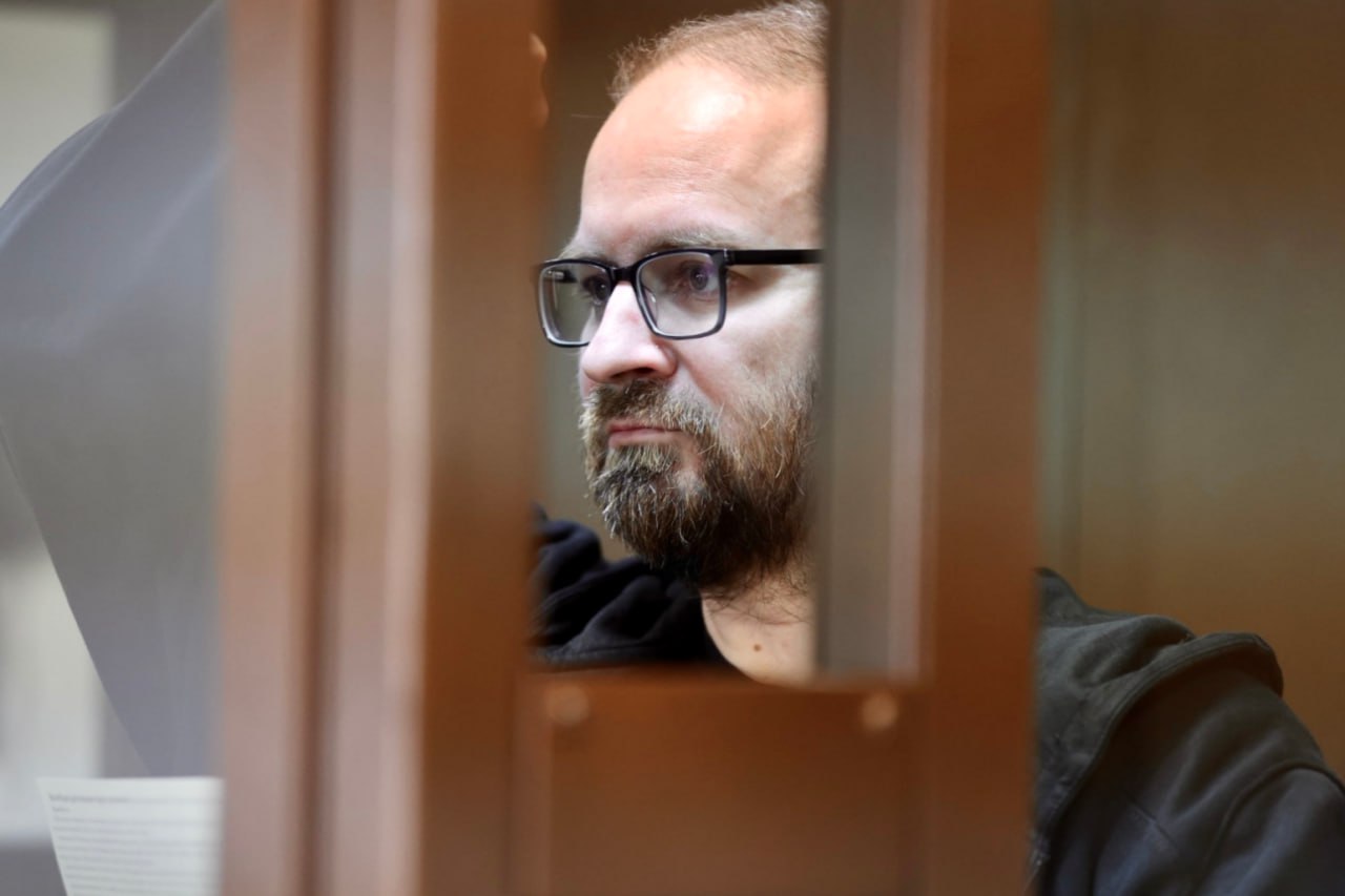 Программисту Илье Васильеву, известному как Арви Хэккер запросили 8,5 лет колонии за пост об обстреле Херсона Об этом сообщает корреспондент «Медиазоны» из зала Преображенского суда Москвы. ФСБ впервые пришла в квартиру Ильи Васильева с осмотром и изъяла у него всю технику 11 мая 2023 года. Он сам разблокировал все устройства и выдал пароли в обмен на обещание, что силовики только «установят отсутствие кураторов из Украины» и через месяц все вернут. В тот же день Васильеву назначили штраф в 40 тысяч рублей за «дискредитацию» армии. Технику ему не вернули, а 22 июня 2024 года после нового обыска отправили в СИЗО по делу о военных «фейках». Дело завели за пост от 25 декабря 2022 года: «Путин отверг рождественское перемирие. Сейчас его ракеты обстреливают мирные украинские города и поселки. Только вчера в Херсоне, где живет семья моего отца, погибли 16 человек. Или жила? Миллионы украинцев сейчас сидят без света и воды. Картина называется Рождество-2022». Сейчас удален не только пост, но и все аккаунты Васильева. Он признал авторство поста, но не признал вину — в суде программист объяснял, что лишь хотел, чтобы «люди остались живыми». Новость о погибших жителях Херсона была для него «очень личной», потому что в городе жили его родственники, о чьей судьбе он «не знает до сих пор». Васильев получил известность в 2000-е годы как IT-энтузиаст. Он основал «Гражданскую школу хэкеров» и до ареста работал в «Московском центре Дзен». Фото: Александра Астахова / Медиазона Ваша регулярная поддержка позволяет нам выжить и говорить о том, что происходит в России: donate.zona.media