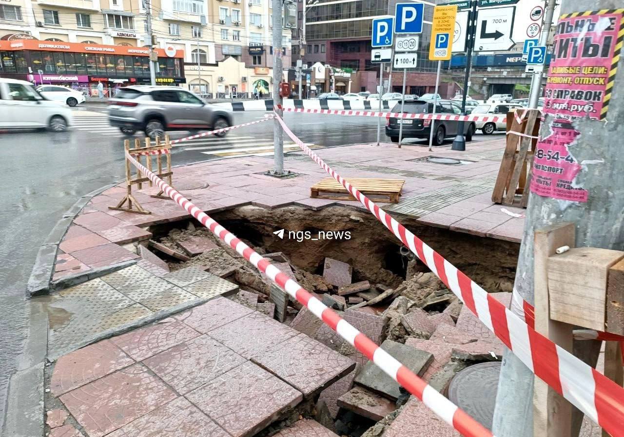 На перекрестке Красного проспекта и Писарева провалилась плитка. Яма занимает почти весь тротуар. Пока что место огородили сигнальной лентой. Фото: АСТ-54 Black