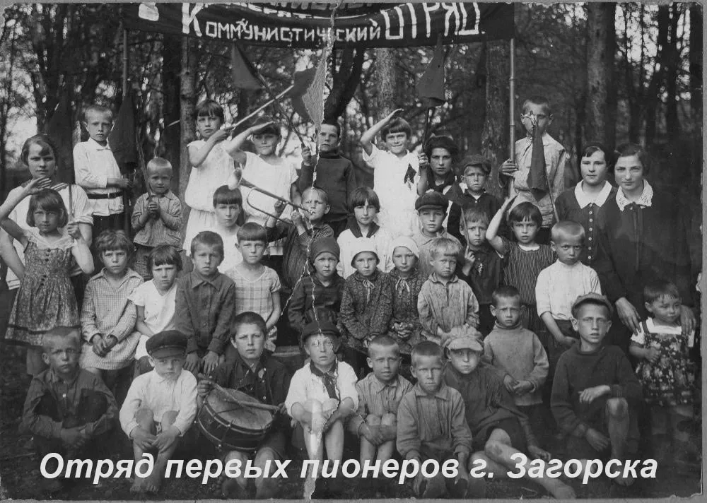 Сегодня день пионерии Всесоюзная пионерская организация им В И Ленина была создана 19 мая 1922 года Когда же в возник первый пионерский отряд в нашем городе Это можно сказать относительно точно в первой половине 1922 года Подтверждение тому есть в опубликованных в газете Вперёд в 1961 году воспоминаниях Николая Павлова одного из первых наших пионеров Он сообщает что вступил в отряд зимой 1922 года в шестилетнем возрасте Местом сбора пионеров был Дом кустаря на перекрестке 1 й Рыбной улицы и проспекта Красной Армии Неудивительно ведь первыми нашими пионерами были дети кооперированных кустарей работавших в бывших Губернских земских мастерских Позднее в 1922 году к ним присоединились дети работников бывшей Зайцевской шелкоткацкой фабрики на Вифанской улице В дальнейшем базой пионеров Сергиева стала Пионеркоммуна располагавшаяся в помещении бывшего Филаретовского училища Александро Мариинского дома призрения до недавнего времени Физико математический лицей Родители первых пионеров смотрели на новое движение как на продвинутый детский досуг с элементами физической подготовки полезный для лучших перспектив жизни в новом обществе Костяком отрядов были вожатые как правило командированные из Москвы комсомольцы К 1925 году в уезде насчитывалось уже до двух с половиной тысяч пионеров В мае 1925 года состоялся первый пионерский парад В мае июне 1929 года по всей стране прошли массовые уездные и губернские пионерские слёты которые потом должны были вылиться во Всесоюзную пионерскую конференцию Состоялся подобный слёт и в Сергиеве готовившимся стать Загорском Первоначально на нём в присутствии старших товарищей и шефов планировалось озвучить информацию о полной ликвидации на территории уезда неграмотности среди населения до 50 лет Но в последний момент этот пункт программы был снят губернский отдел народного образования обнаружил что цифры были мягко говоря завышены К 1990 му пионерское движение полностью свернуло свою деятельность И только спустя 20 лет в стране стали задумываться о создании новых молодежных организаций Движении Первых Молодой гвардии Единой России и других