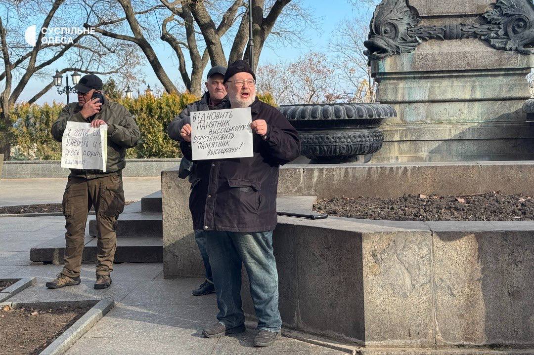 Возле горсовета в Одессе собрались люди с требованием восстановить памятник Высоцкому  Их немного, но они есть.   "Я вам мозги не пудрю — уже не тот завод: В меня стрелял поутру из ружей целый взвод. За что мне эта злая, нелепая стезя — Не то чтобы не знаю, — рассказывать нельзя.  Мой командир меня почти что спас, Но кто-то на расстреле настоял — И взвод отлично выполнил приказ. Но был один, который не стрелял..."  Владимир Высоцкий