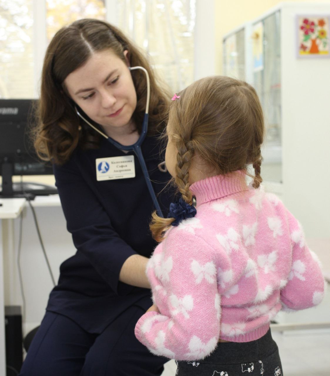 Сегодня День педиатра Это праздник тех кто первым встречает маленького пациента и сопровождает его на пути к здоровью Среди таких врачей Софья Андреевна Колесникова педиатр Ипатовской детской поликлиники Она успела завоевать доверие сотен семей для которых её имя стало синонимом заботы и профессионализма С А Колесникова выбрала медицину ещё в школьные годы интерес к химии и биологии определил направление в жизни В 2016 году она поступила на педиатрический факультет в 2025 году окончила ординатуру по специальности Педиатрия Вернулась в родной город чтобы работать с детьми Рабочие будни педиатра наполнены разными историями Простуды кишечные инфекции нарушения сна боли в животе тревоги родителей всё это проходит через руки и сердце доктора За каждой жалобой Софья Андреевна видит не только болезнь а конкретного ребёнка и его семью В её подходе нет шаблонов каждому пациенту особое внимание каждому родителю понятное объяснение и поддержка