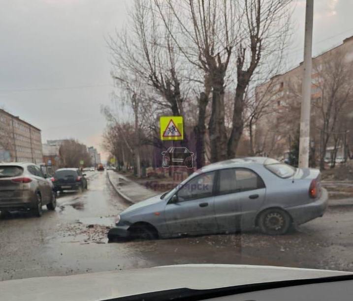 В Красноярске на Новосибирской машина провалилась в огромную яму.  Судя по фото с места, автомобиль марки Chevrolet провалился передними колесами в яму на выезде из двора на улицу Новосибирскую. Пострадавших в происшествии нет.  Автомобилисты пишут, что этой яме уже минимум два года — ее постоянно засыпают щебнем, но весной, с приходом тепла и таянием снега, её размывает.  Фото