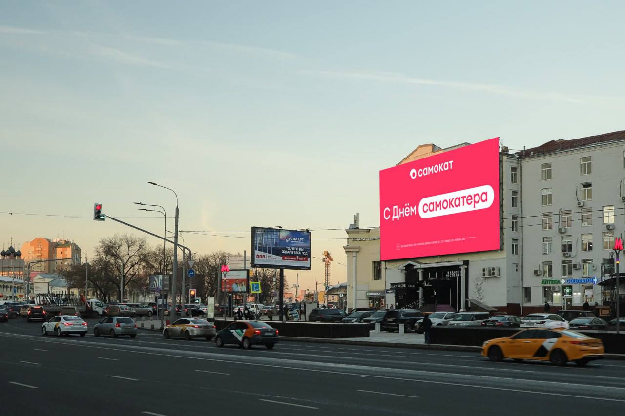 Ко Дню курьера это сегодня онлайн ритейлер Самокат запустил рекламную кампанию в неё вошла наружная реклама видеоролик и интерактивный лендинг на котором можно собрать забавную открытку с поздравлением В этом году в кампании используют слова из речи курьеров партнёров как они сами себя называют Среди поздравлений не только привычное С Днём курьера но и С Днём машины шкипера выходничка легенды и самокатера Необычные поздравления можно увидеть на медиафасадах и в кинотеатрах в Москве Санкт Петербурге и других городах России Юлия Попова руководитель отдела развития HR бренда в Самокате прокомментировала В декабре когда кругом суета нам хотелось привлечь внимание аудитории необычными и цепляющими фразами В рекламной кампании есть невыдуманные слова которые курьеры партнёры используют в своей речи Для нас важно подчеркнуть что мы не просто ценим наших партнёров но и говорим с ними на одном языке День курьера важная дата для Самоката и каждый год мы поздравляем и благодарим наших партнёров за то как много важного они делают ежедневно Как вам креатив Кажется что весь декабрь это месяц курьеров HR4PR