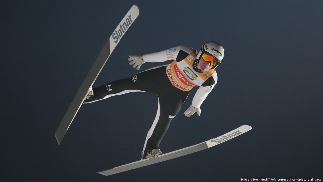 Олимпиада в Милане началась с допинг скандала вокруг уколов в пенис Подозрения вызвали прыгуны на лыжах с трамплина Немецкий таблоид Bild написал в январе что некоторые спортсмены якобы делают инъекции гиалуроновой кислоты в половой член перед официальными замерами тела для пошива комбинезонов Предполагается что это могло увеличить окружность на 1 2 см и как следствие повлиять на параметры экипировки Подтверждений этим утверждениям нет но тема быстро вышла за пределы таблоидов Агентство Reuters подтвердило 5 февраля что на ЧМ 2025 из за манипуляций со швами в области промежности временно дисквалифицировали спортсменов из Норвегии В СМИ скандал уже назвали пенисгейтом 5 февраля гендиректор Всемирного антидопингового агентства WADA Оливье Ниггли пообещал изучить этот вопрос По его словам гиалуроновая кислота не входит в список запрещенных веществ но нужно выяснить может ли подобная процедура считаться недопустимым способом повышения результата Ниггли подчеркнул что WADA занимается именно допингом а не методами улучшения формы 6 февраля со схожим заявлением выступил президент WADA Витольд Банька В прыжках с трамплина размеры и посадка костюма критически важны перед сезоном спортсменов сканируют 3D системами а форма шьется по строгим допускам обычно лишь на несколько сантиметров больше фактических параметров тела При этом фиксируется и высота паховой области от которой зависит крой в одной из ключевых аэродинамических зон Теоретически увеличение объема в этой части может повлиять на площадь поверхности костюма и его поведение в потоке воздуха Британская Daily Mail пишет об исследовании опубликованном в журнале Frontiers в котором сообщается что изменение окружности костюма на 2 см увеличивает подъемную силу на 5 что эквивалентно дополнительным 5 8 метра длины прыжка В Международной федерации лыжного спорта и сноуборда FIS признают что даже небольшие изменения костюма могут сказаться на дальности полета Директор мужских соревнований по прыжкам с трамплина Сандро Пертиле отмечал что каждый дополнительный сантиметр имеет значение поскольку рост площади костюма может добавить подъемной силы В то же время в FIS утверждают что никогда ранее не сталкивались с подобными экзотическими методами и не располагают доказательствами их применения Дискуссия вокруг пенисгейта в спортивном мире продолжается dwglavnoe