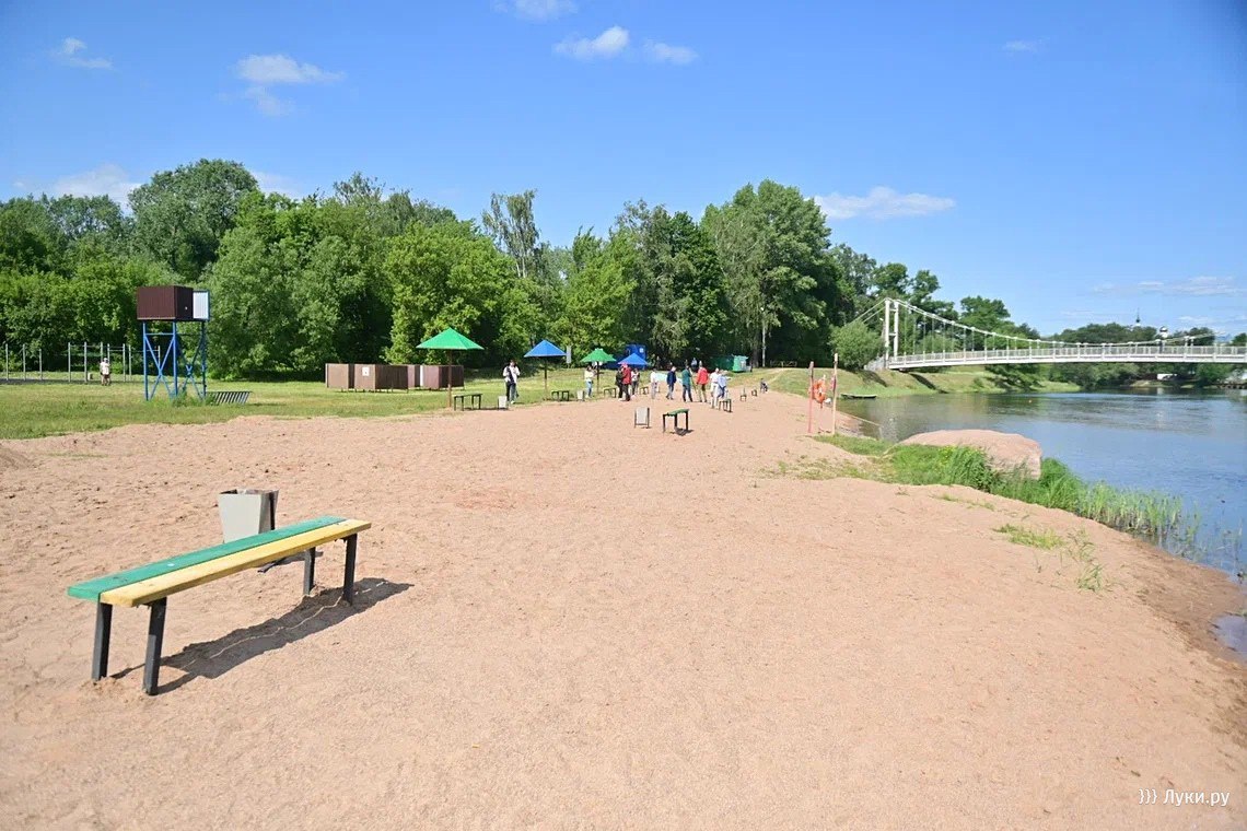 В Великих Луках начали благоустраивать городской пляж На территории городского пляжа установят урны, скамейки, дачные беседки, модульные туалеты и раздевалки. Также здесь появятся пешеходные дорожки, будет организован проезд для транспорта и парковка. Зона отдыха будет оборудована речным песком, а часть территории засеют газонной травой. На пляже также появится освещение. Работы планируют завершить в течение летнего сезона.