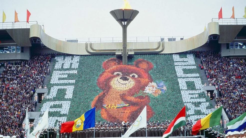 19 июля 1980 года в Москве открылись XXII летние Олимпийские игры  В Олимпиаде-80 приняли участие более 5 тысяч спортсменов из 81 страны мира. Было разыграно 203 комплекта медалей в 21 виде спорта. Лидерами неофициального медального зачета стали советские спортсмены, которые завоевали 80 золотых, 69 серебряных и 46 бронзовых. На втором месте оказалась сборная ГДР  47 золотых, 37 серебряных и 42 бронзовых , на третьем — Болгарии  8 золотых,16 серебряных,17 бронзовых .  Талисманом XXII летних Олимпийских игр стал Олимпийский Мишка, созданный художником-иллюстратором Виктором Чижиковым. Одним из самых трогательных моментов Олимпиады-80 стал полет Мишки на воздушных шарах под песню Александры Пахмутовой и Николая Добронравова «До свидания, Москва» во время церемонии закрытия 3 августа.    ОКР и МОК