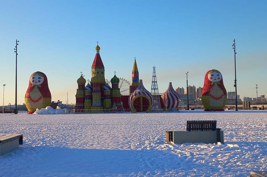 Благовещенск активно украшают к Новому году Основные работы стартовали конце октября Первыми смонтировали светодиодные конструкции К уже привычным елочным шарам и аркам добавили полумесяц фонтан карету снеговиков и медведей В конце недели планируют начать монтаж искусственных новогодних елок Первыми украсят парк Дружбы площадку у Общественно культурного центра Плодопитомник и Моховую Падь Чуть позже новогоднее дерево появится и на площади Ленина Сейчас здесь монтируют зимний городок Корреспондент Amur life сфотографировал начальный этап работ пока стоят нераспокованные детали даже угадать трудно что это будет Здесь появятся как традиционные Дед Мороз и Снегурочка так и новые фигуры дядька Черномор скоморохи а также комета самовар музыкальные инструменты разнообразные арки Уже стоит забавная сказочная печка Рядом с одной из крупнейших на Дальнем Востоке тюбинговых горок установят 8 метровую матрёшку 11 метровый Кремль и собор Василия Блаженного высотой 13 метров сообщили в мэрии Фото Amur life