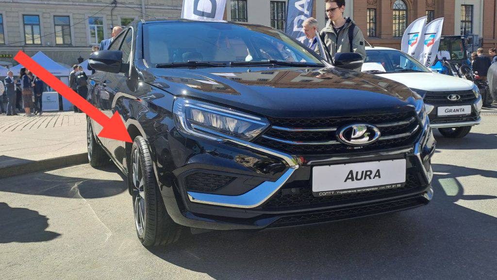 АвтоВАЗ не перестает радовать своими ноу-хау    В новой представительской Lada Aura  удлиненная Vesta  решили поставить колеса пошире, но столкнулись с проблемами при сертификации автомобиля. ведь теперь колеса выходят за крыло машины.  Любой автопроизводитель расширил бы крылья, но АвтоВАЗ пошел другим путем: приклеили небольшие кусочки пластика. Причем на тех машинах, которые изначально показывали прессе, таких «расширителей» не было.  Чувствуется почерк людей, которые прямо на заводе  !  пилили трехдверную Ниву пополам, чтобы сделать из нее пятидверную.  С вас 3 000 000₽ за бизнес-седан, который «превосходит Totota Camry»