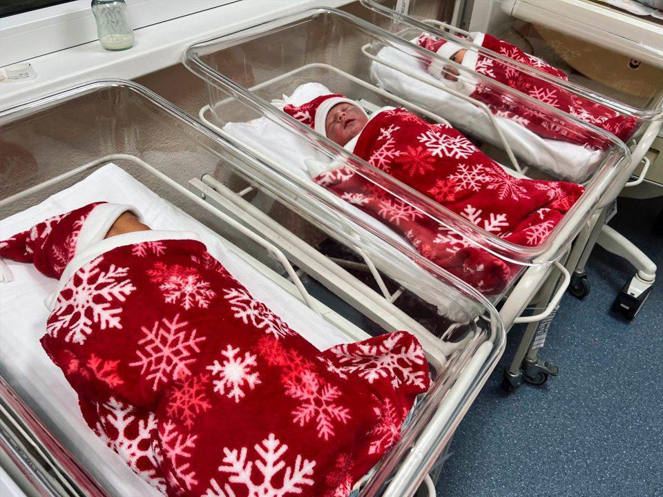 В Подмосковье стартовала акция для декабрьских новорожденных Родителям передают детей в новогодних костюмах включая красный колпачок Деда Мороза и одеяло со снежинками bankser