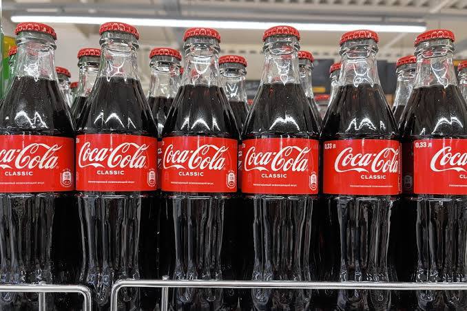 Coca-Cola уже готовится к возвращению в Россию. Внутри компании вовсю обсуждают стратегию по работе с отечественными конкурентами и борьбе с параллельным импортом после потепления отношений РФ и США. По данным Mash, производители планируют делать её на тех же заводах, что и до ухода из РФ.   Как только оригинал вернётся в Россию, компания начнёт бороться с подделкой, произведённой в Подмосковье, Казахстане, Киргизии и Китае. А главный конкурент — «Добрый. Кола» продолжит работать и дальше. Но если аналитики увидят, что американский гигант их поглощает, то российский бренд откажется от затеи производить аналог.